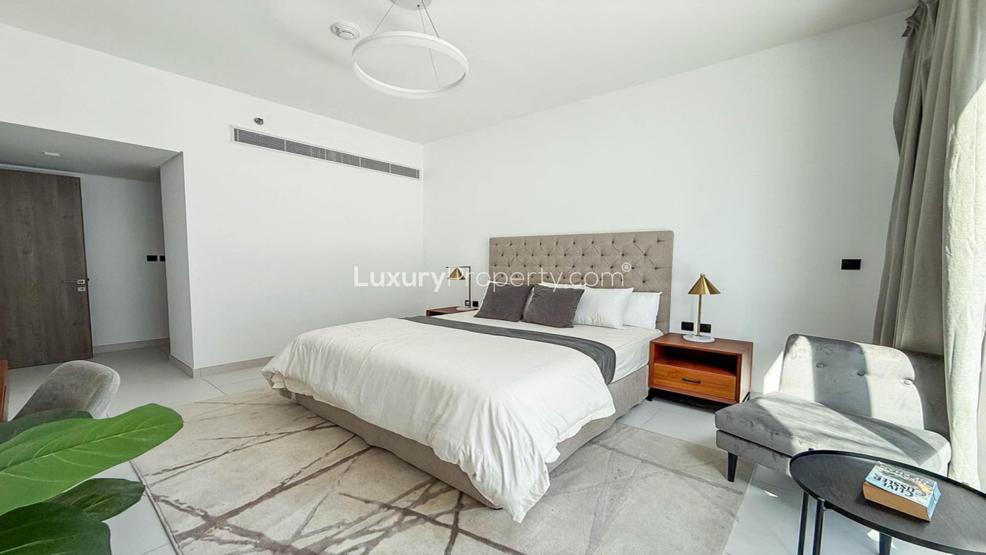 Modern kitchen and living area in Palm Jumeirah apartment, featuring natural light and sleek design