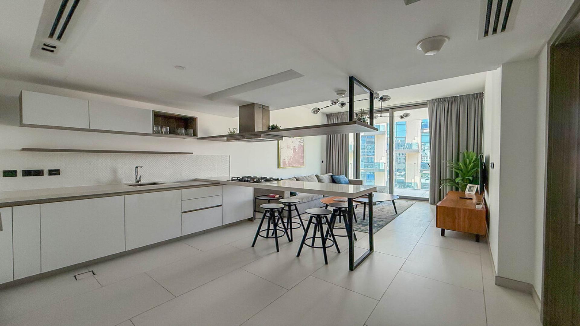 Modern living room in Soho Palm Jumeirah apartment with open kitchen and stylish decor