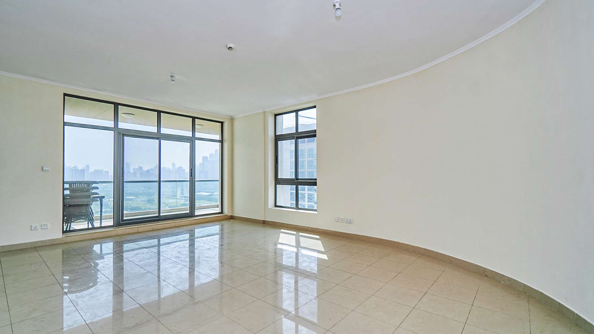 Balcony view from Links West Tower apartment overlooking golf course and city skyline