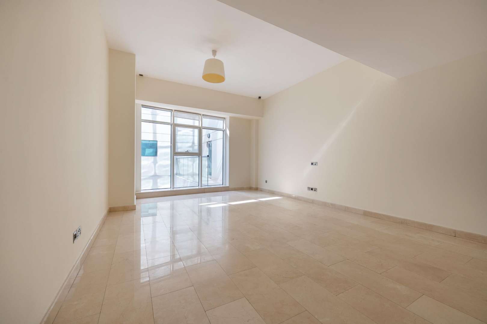 Bright living room with large windows in Trident Bayside apartment, Dubai Marina