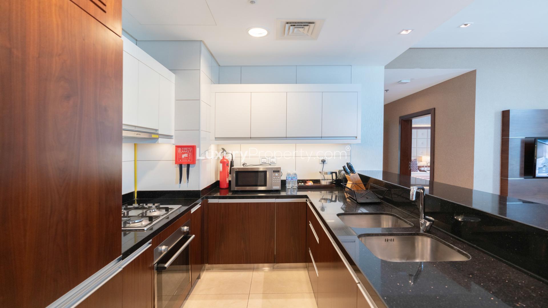 Modern furnished kitchen and living area in Business Bay apartment, Royal Continental Suites