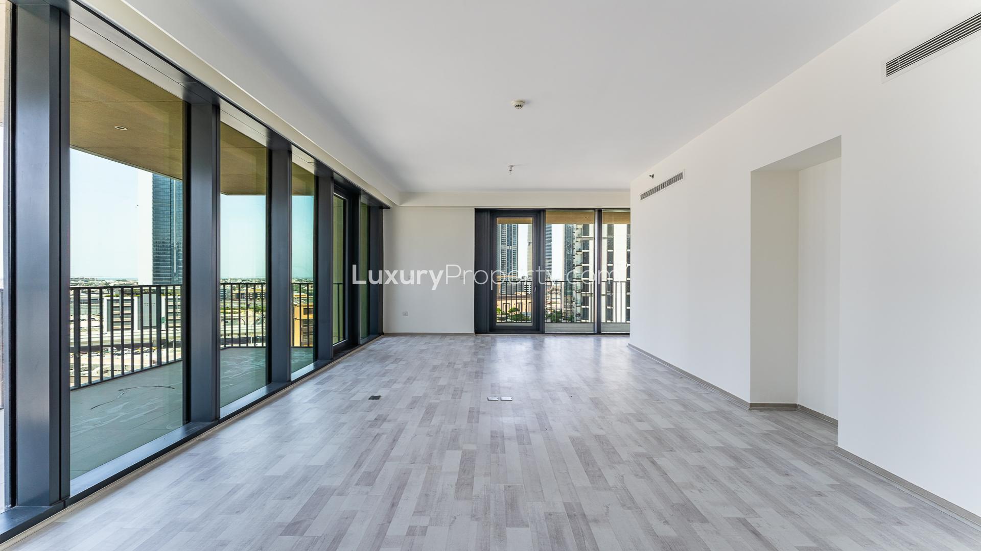 Spacious living area with floor-to-ceiling windows and balcony view in Downtown Dubai apartment