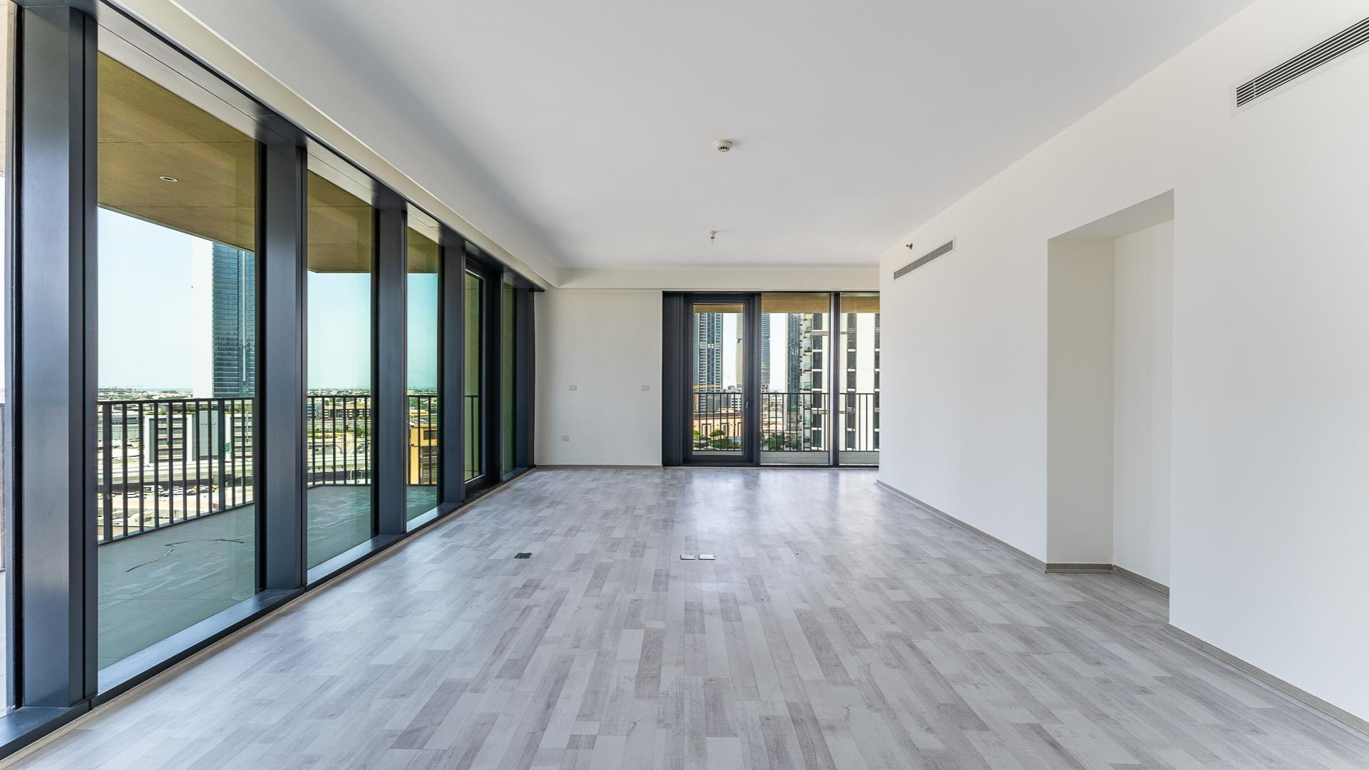 Spacious living area with floor-to-ceiling windows and balcony view in Downtown Dubai apartment