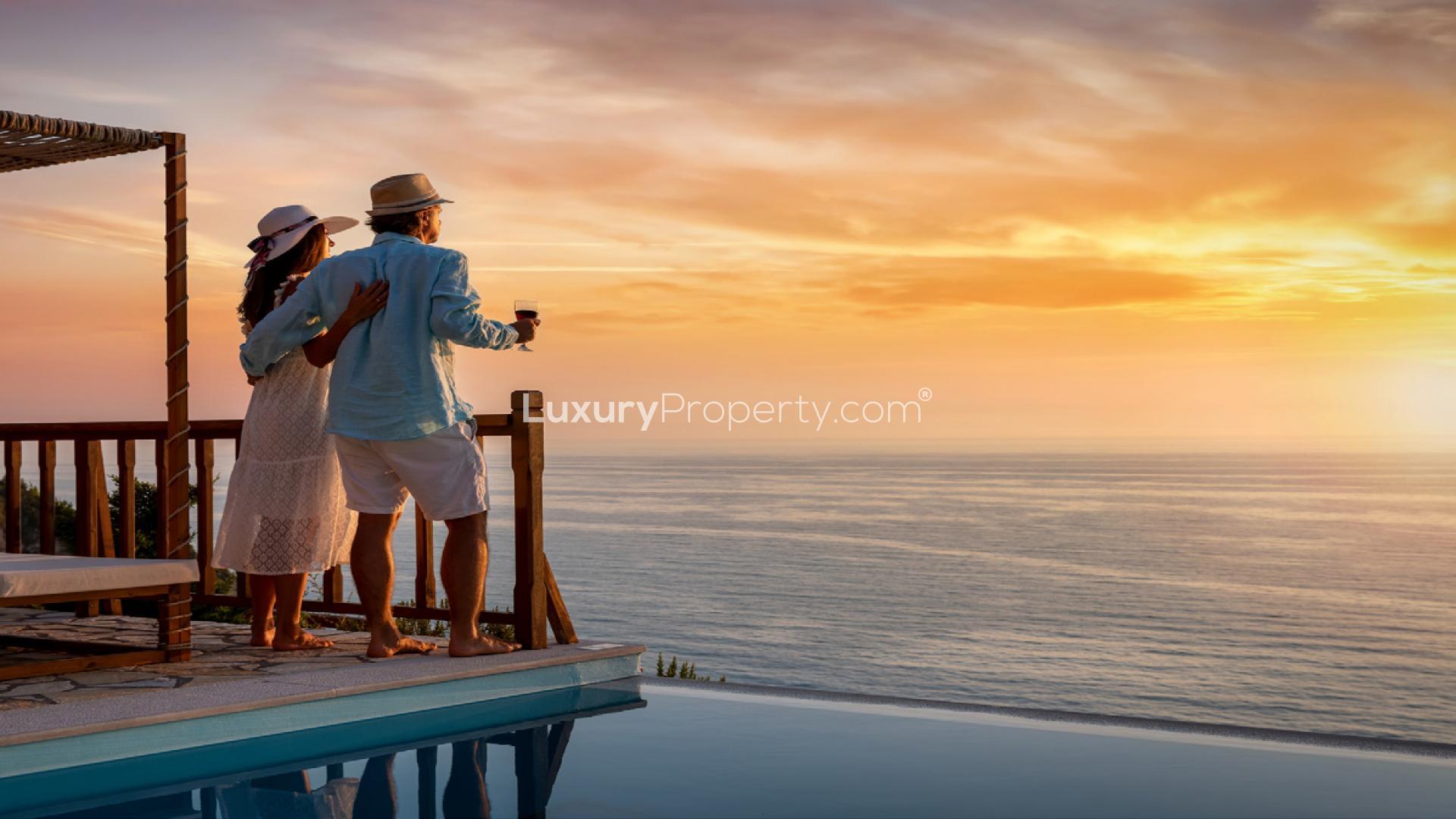 Couple enjoying sunset view from luxury apartment in Mina Rashid, overlooking the ocean