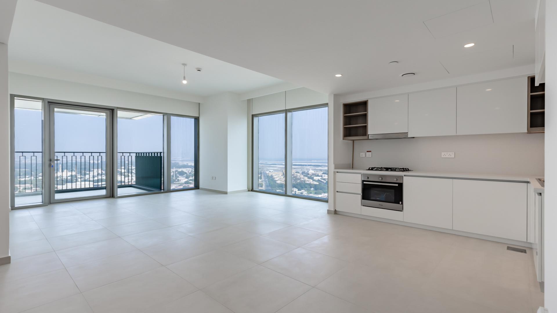 Modern open-plan kitchen and living area in Downtown Dubai apartment, large windows, bright interior