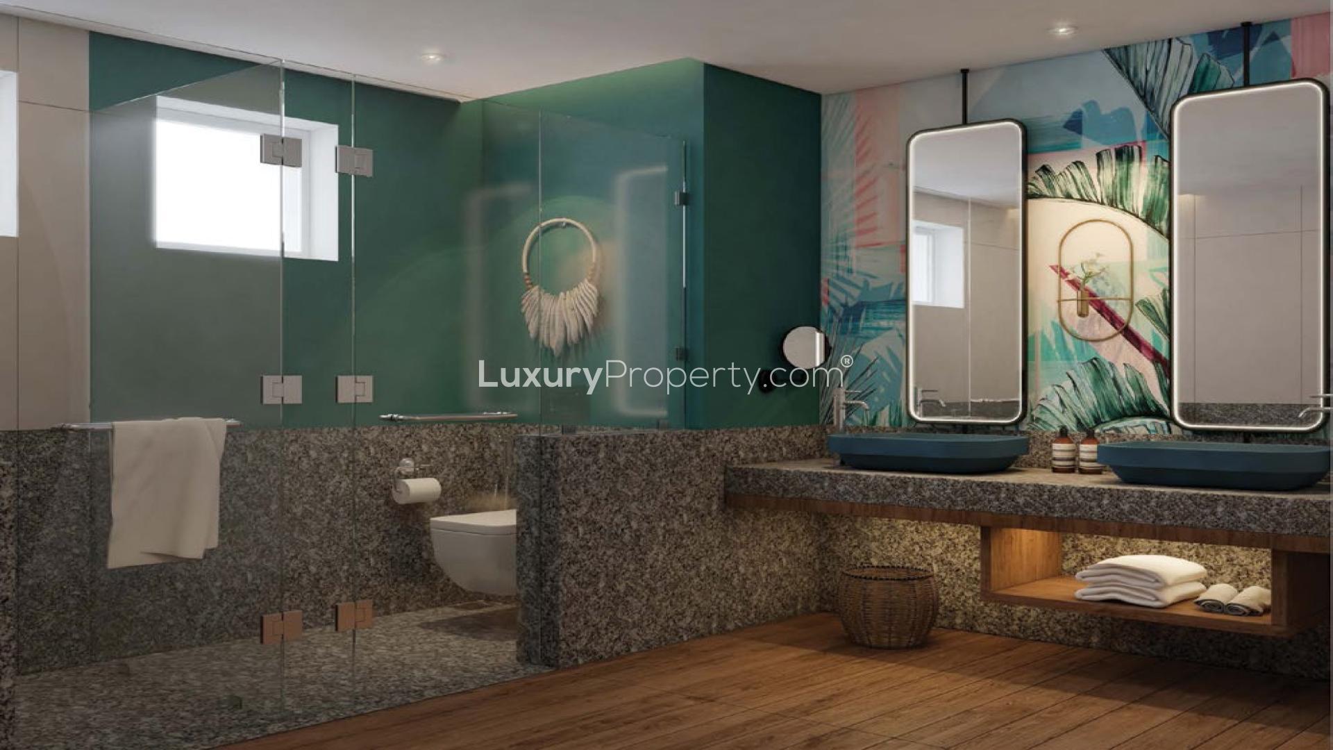 "Stylish living room in Albizya North Apartment, Mahe with modern decor and ambient lighting.",Scenic beach view from Albizya North Apartment, Mahe, with boats and lush greenery