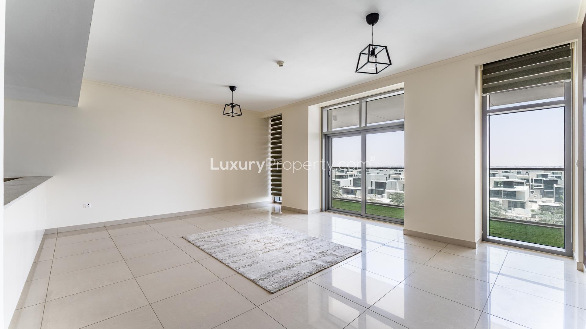 Modern living room with marble accent wall and park view in Dubai Hills Estate apartment