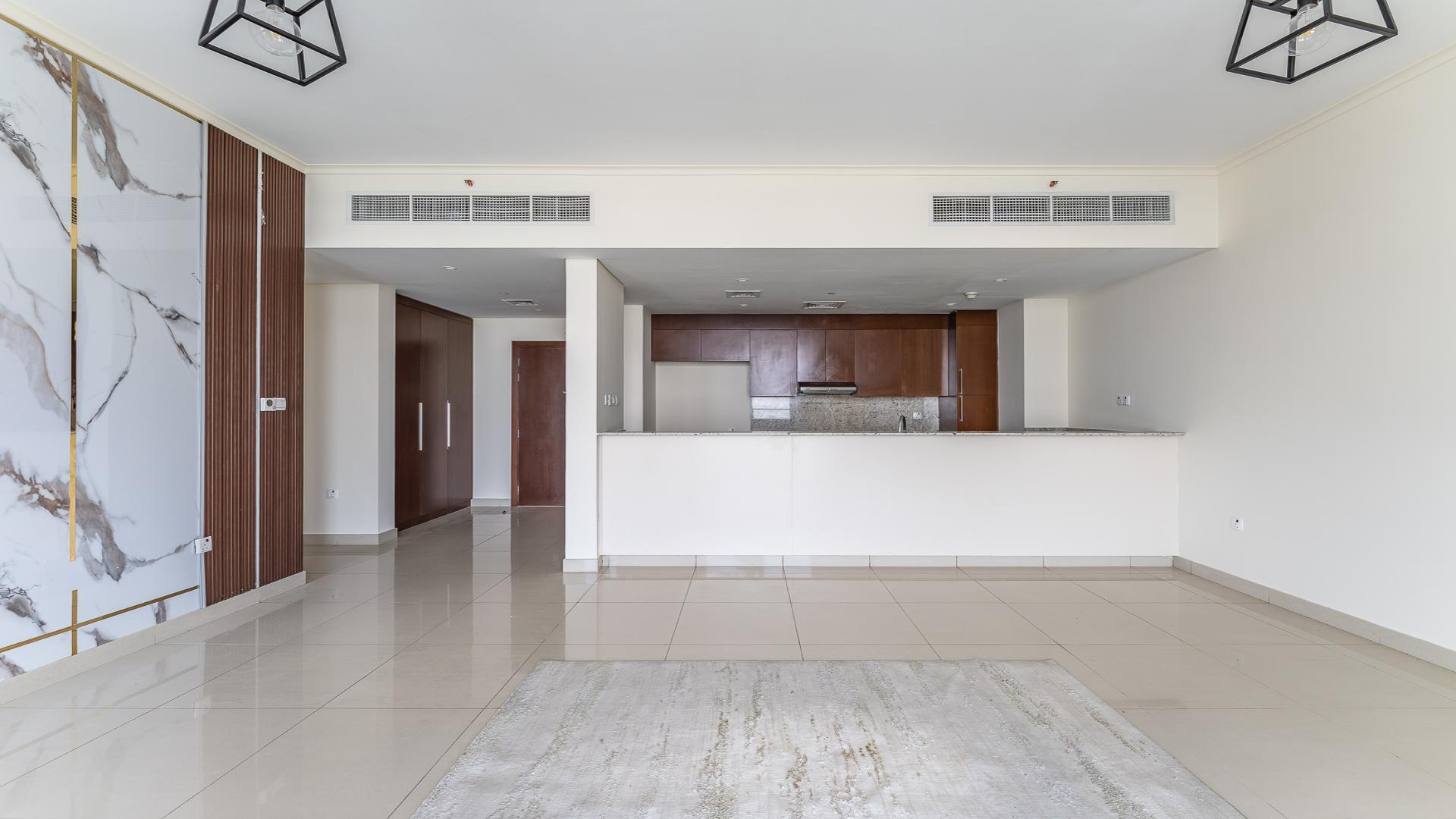 Bright living room with large windows overlooking Dubai Hills Estate in Park Heights apartment