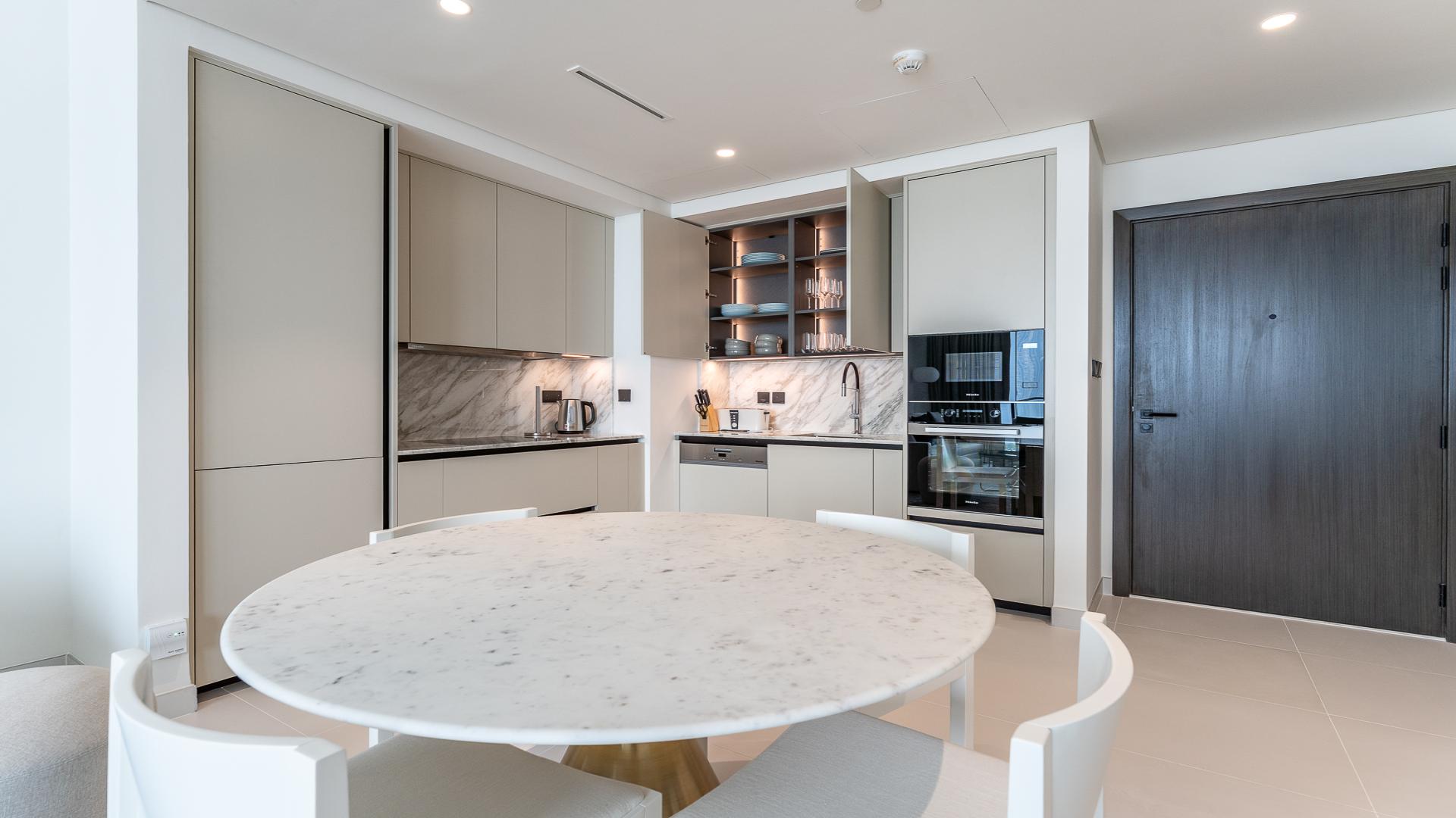 Modern kitchen with marble table in Marina Vista apartment, Emaar Beachfront, Dubai Harbour