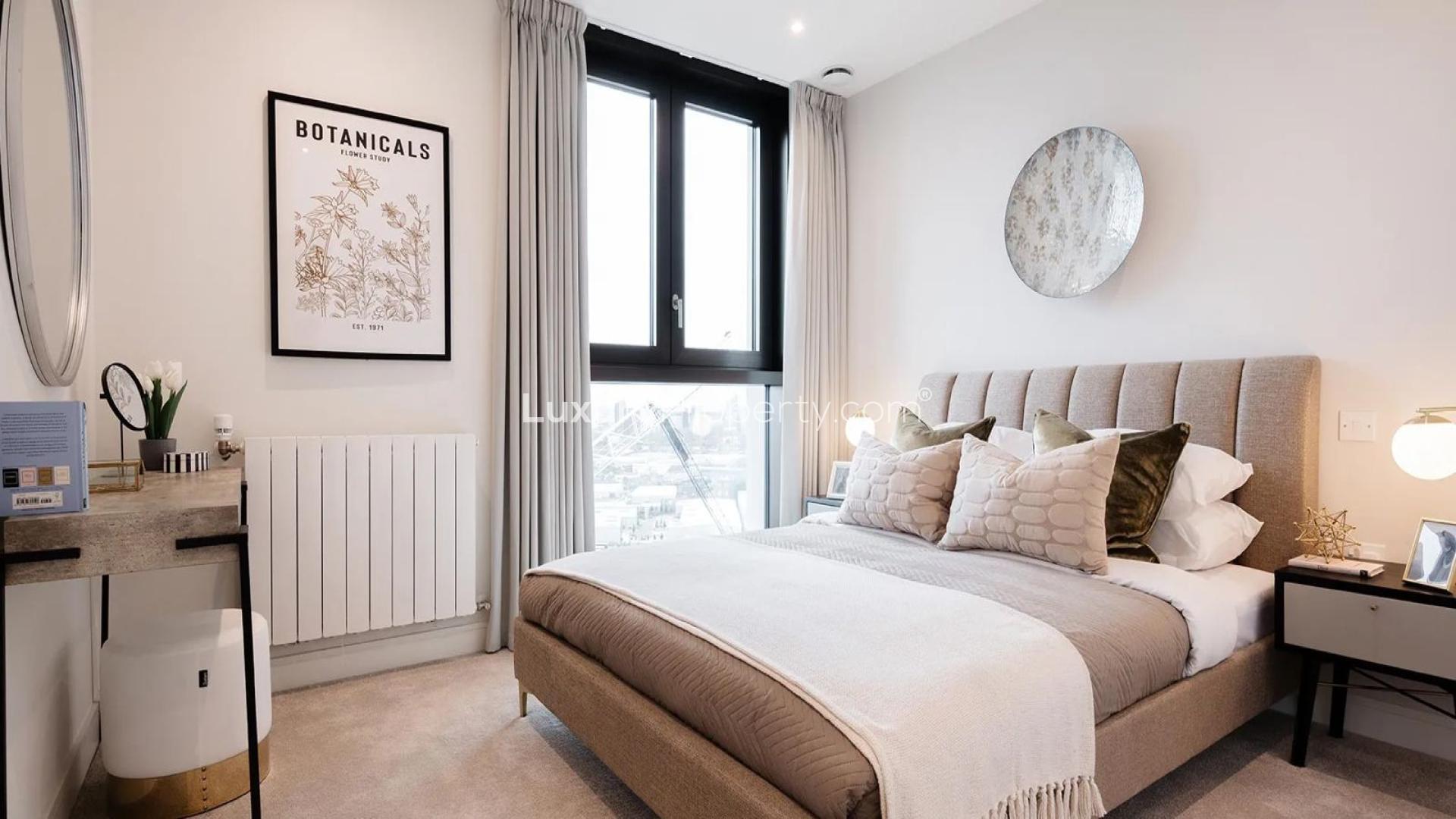 Modern bedroom in Evergreen Point apartment, TwelveTrees Park, London, with city skyline views