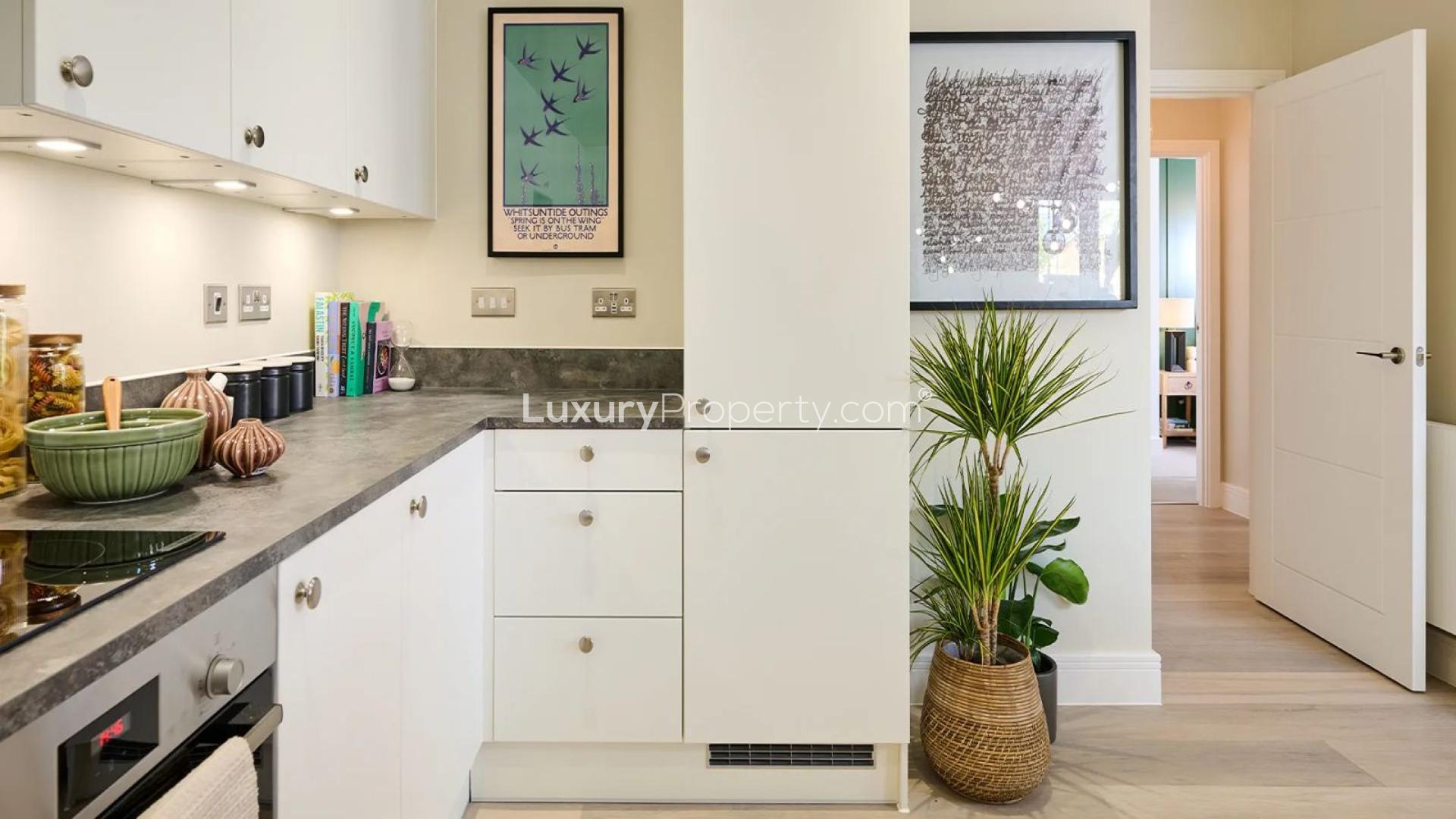 Modern kitchen in Highcroft apartment, London, featuring sleek cabinets and dining area