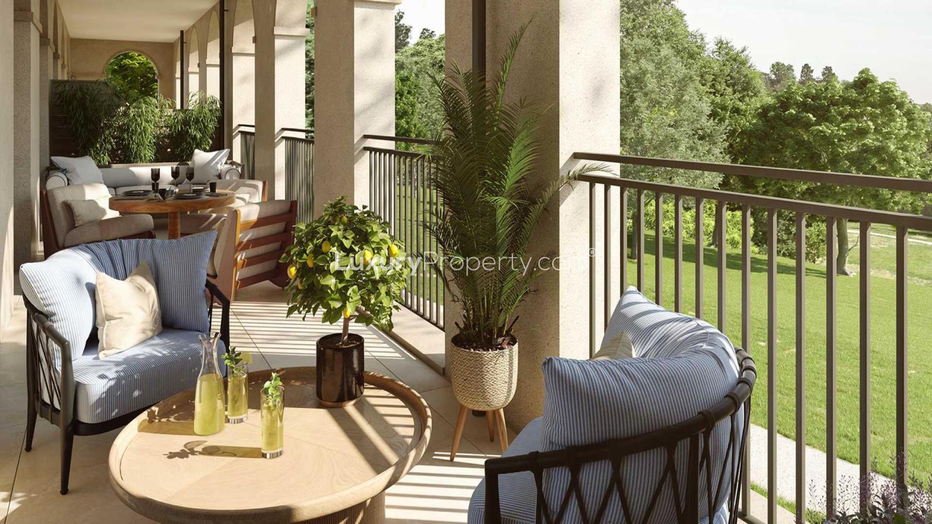 "Spacious apartment balcony with scenic park views in Sunningdale Park, London, for sale.",Luxurious apartment balcony with seating, lush greenery, and park views in Sunningdale Park, London