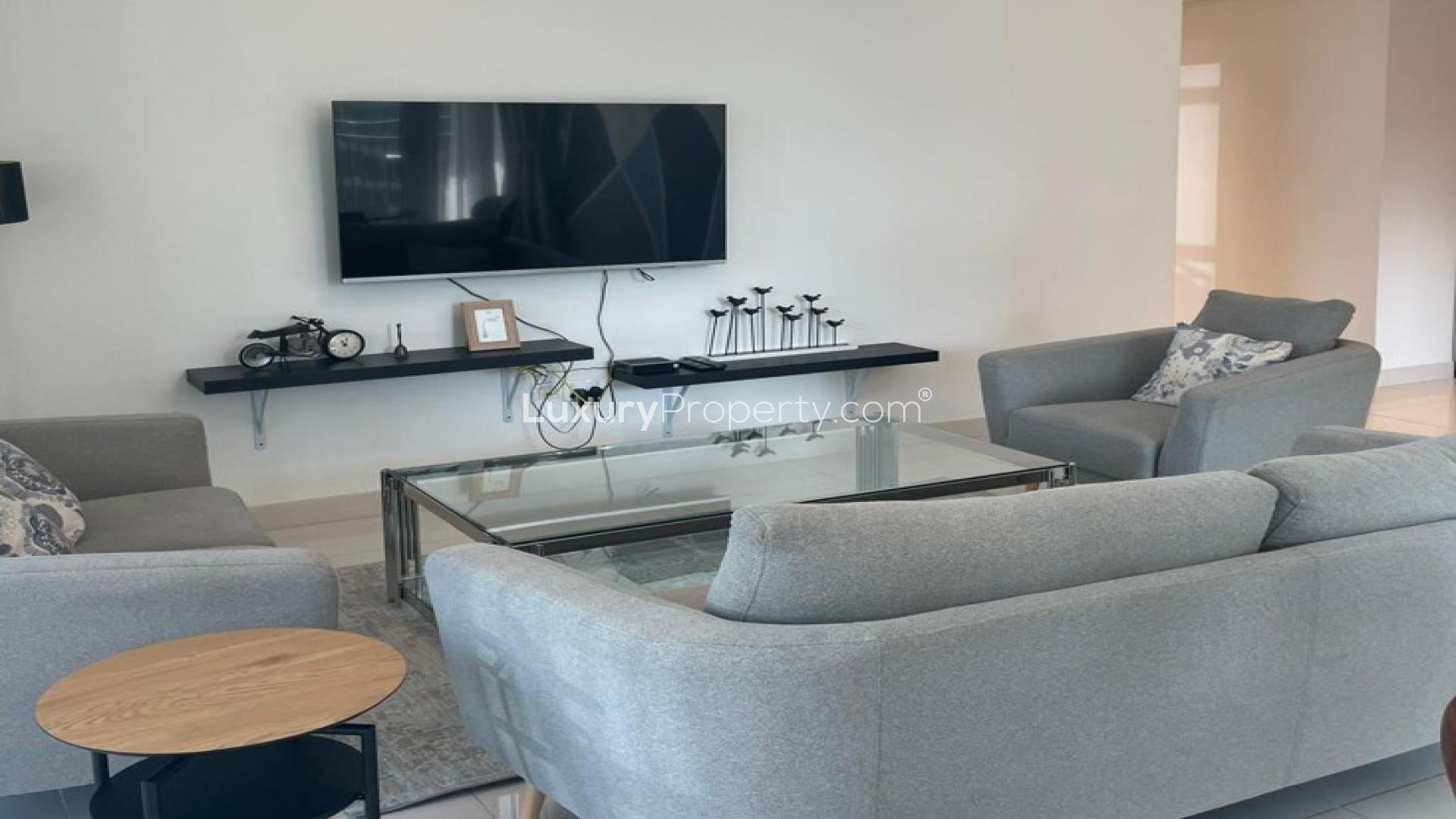 N/A,Modern living room in Downtown Dubai apartment, featuring sleek furniture and wall-mounted TV
