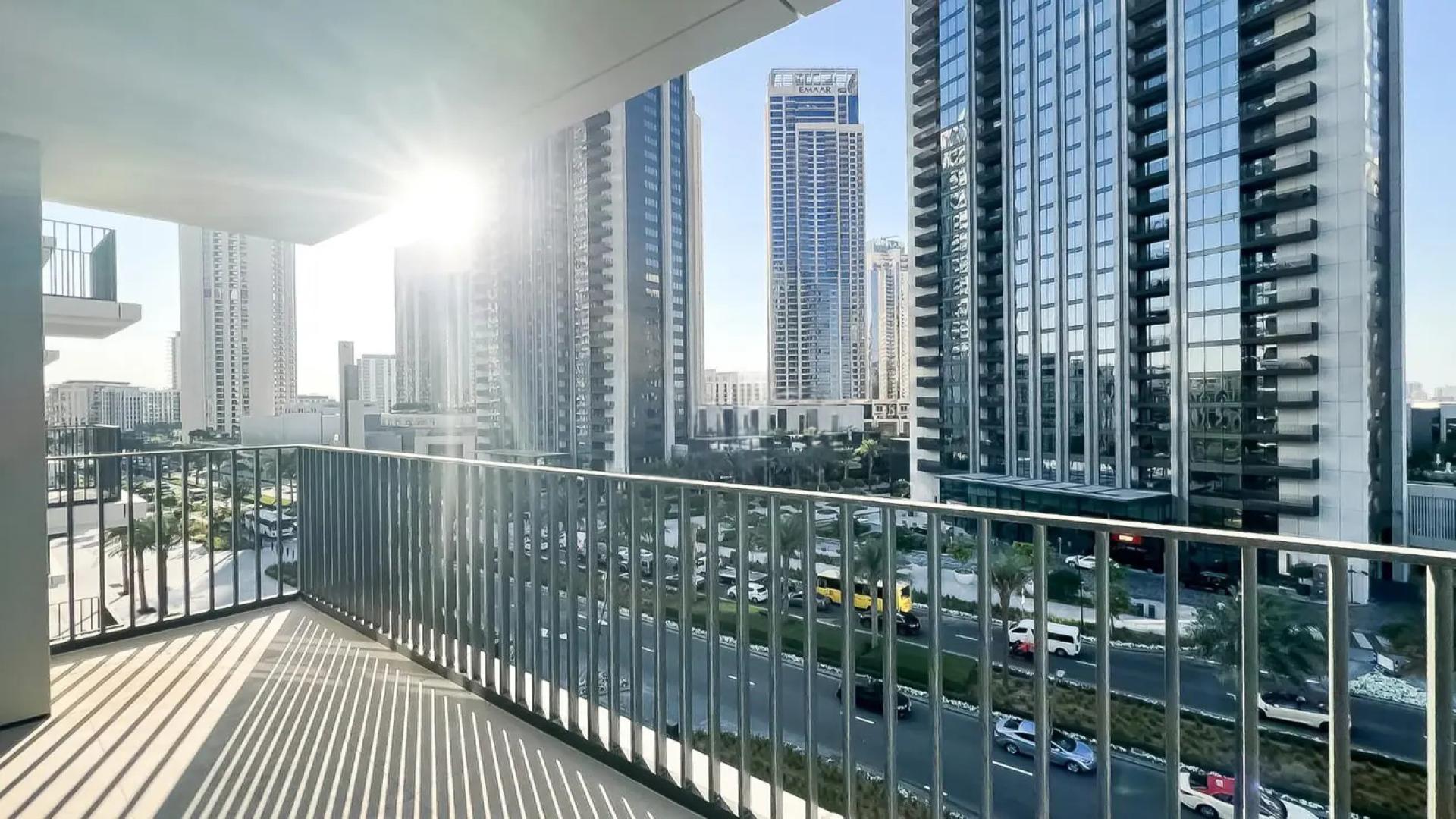 Empty bedroom in Palace Residences, Dubai Creek Harbour, featuring built-in wooden wardrobe