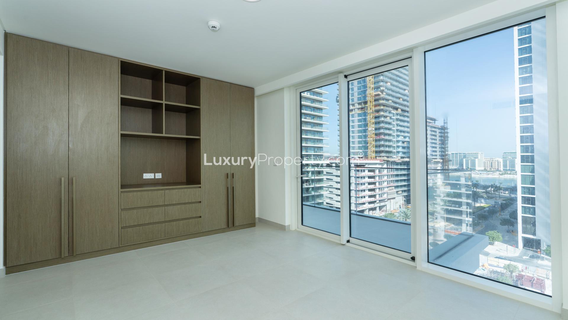 Emaar Beachfront apartment balcony view overlooking modern skyscrapers and city street