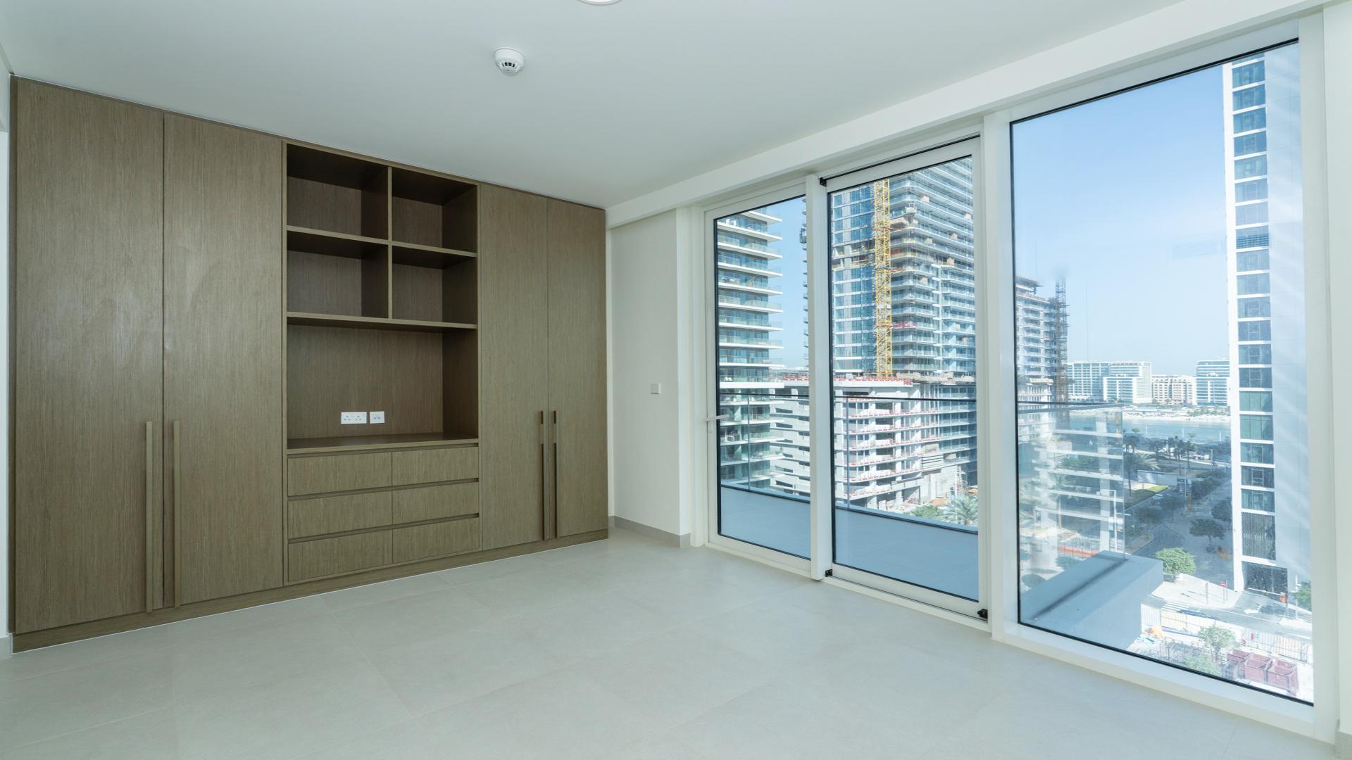 Emaar Beachfront apartment balcony view overlooking modern skyscrapers and city street