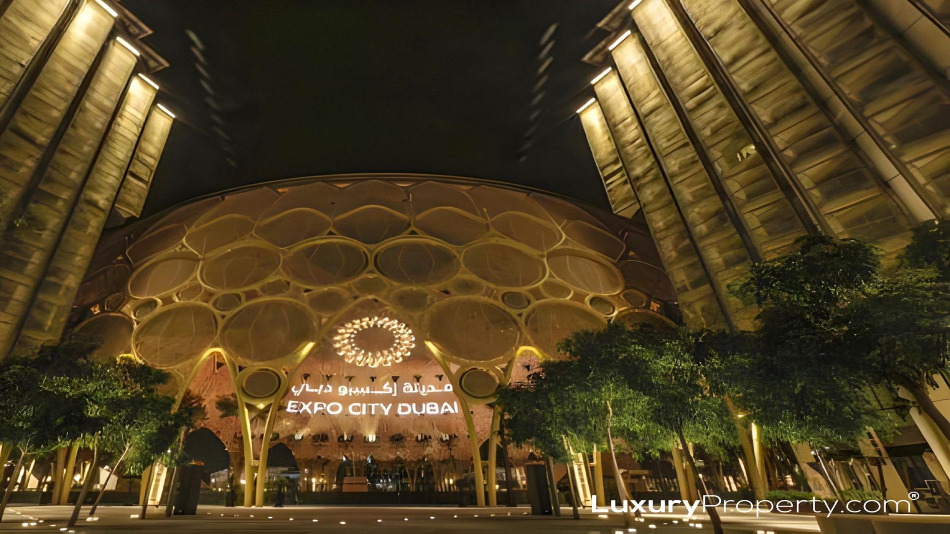 Modern apartment exterior in Al Waha Residences, Expo City, with outdoor seating and greenery