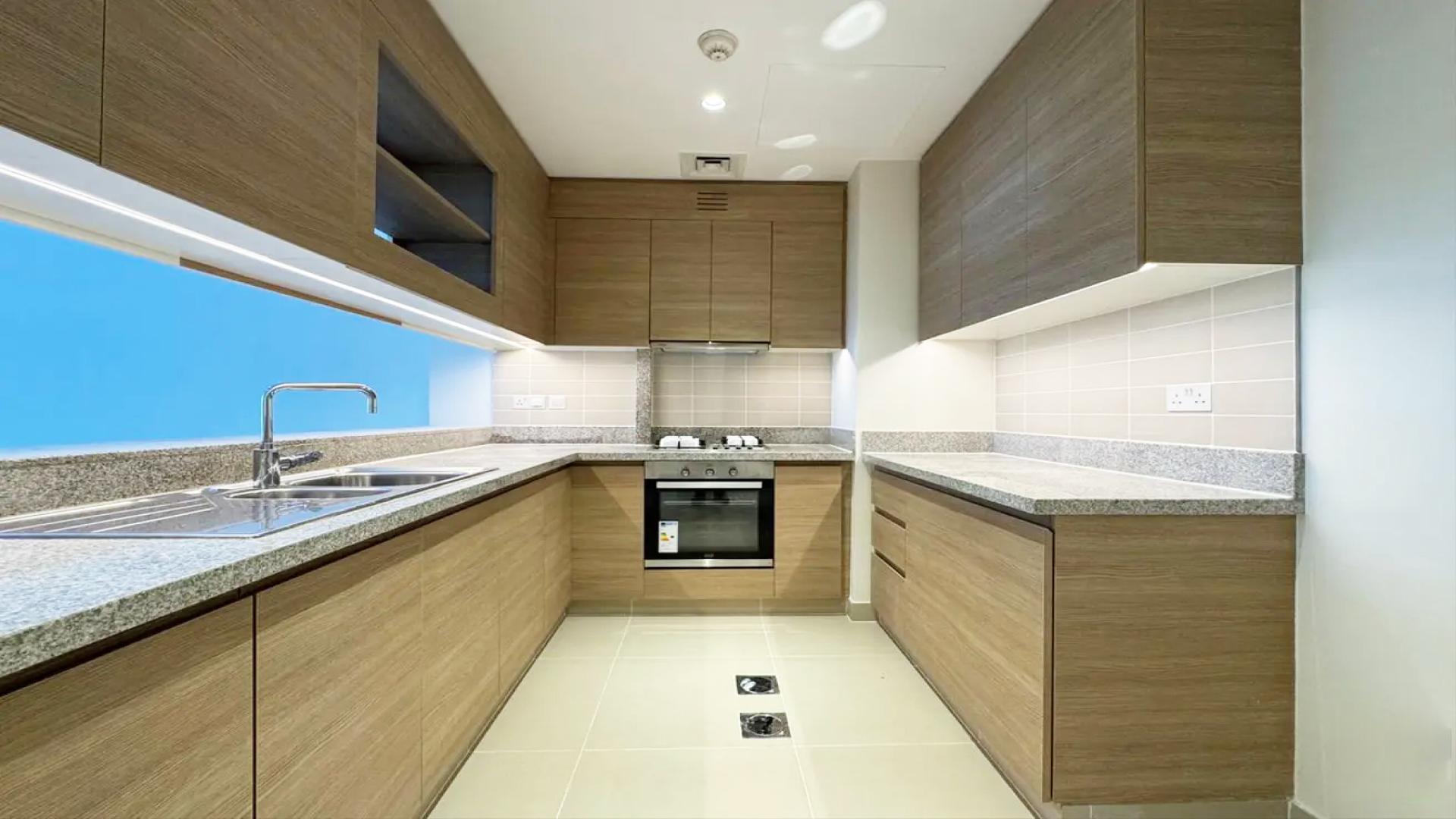 Modern kitchen in 2-bedroom apartment, Acacia C, Dubai Hills Estate, featuring sleek wood cabinets