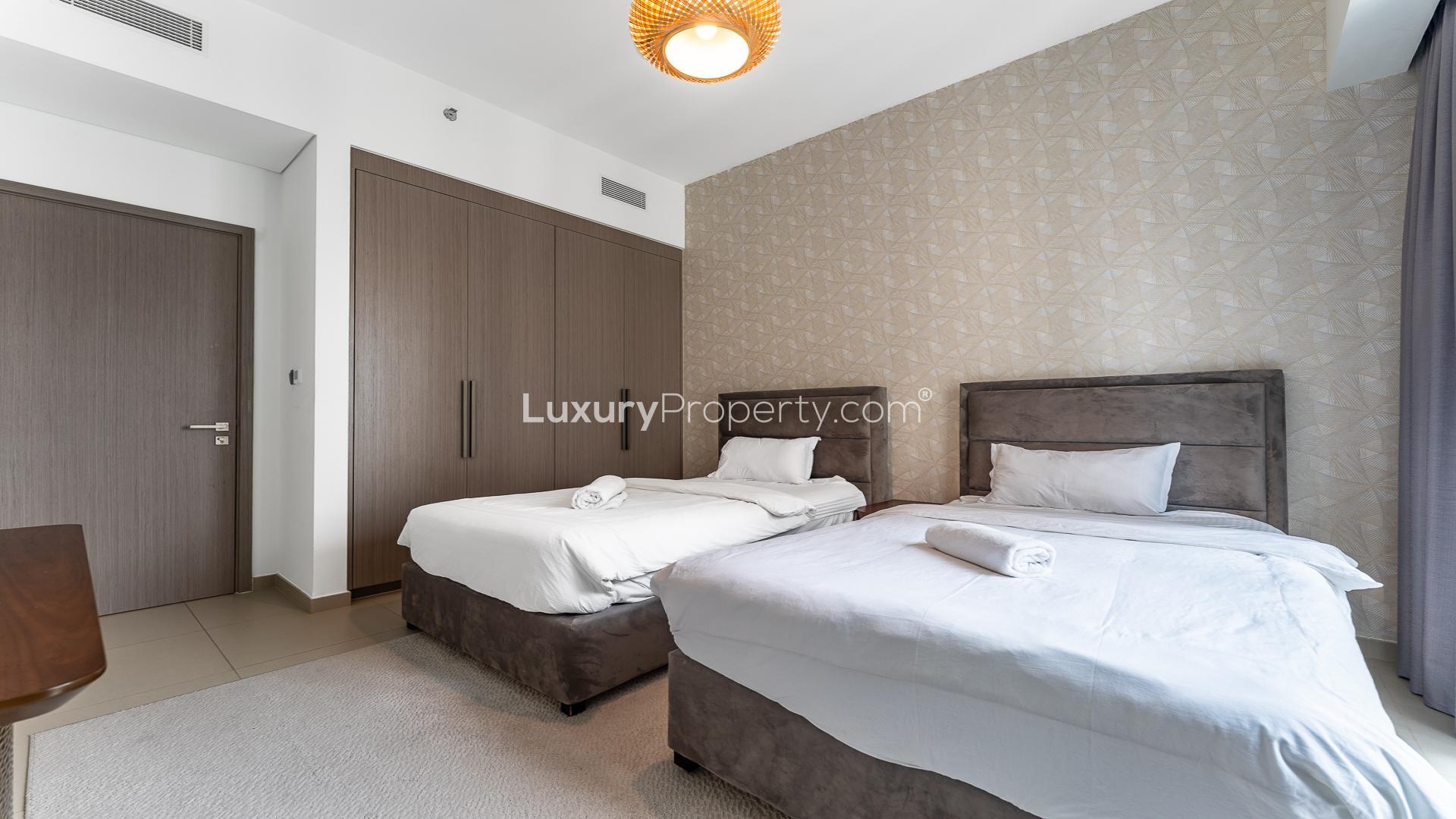 Fully furnished bedroom in Act Towers apartment, Downtown Dubai, with cityscape view