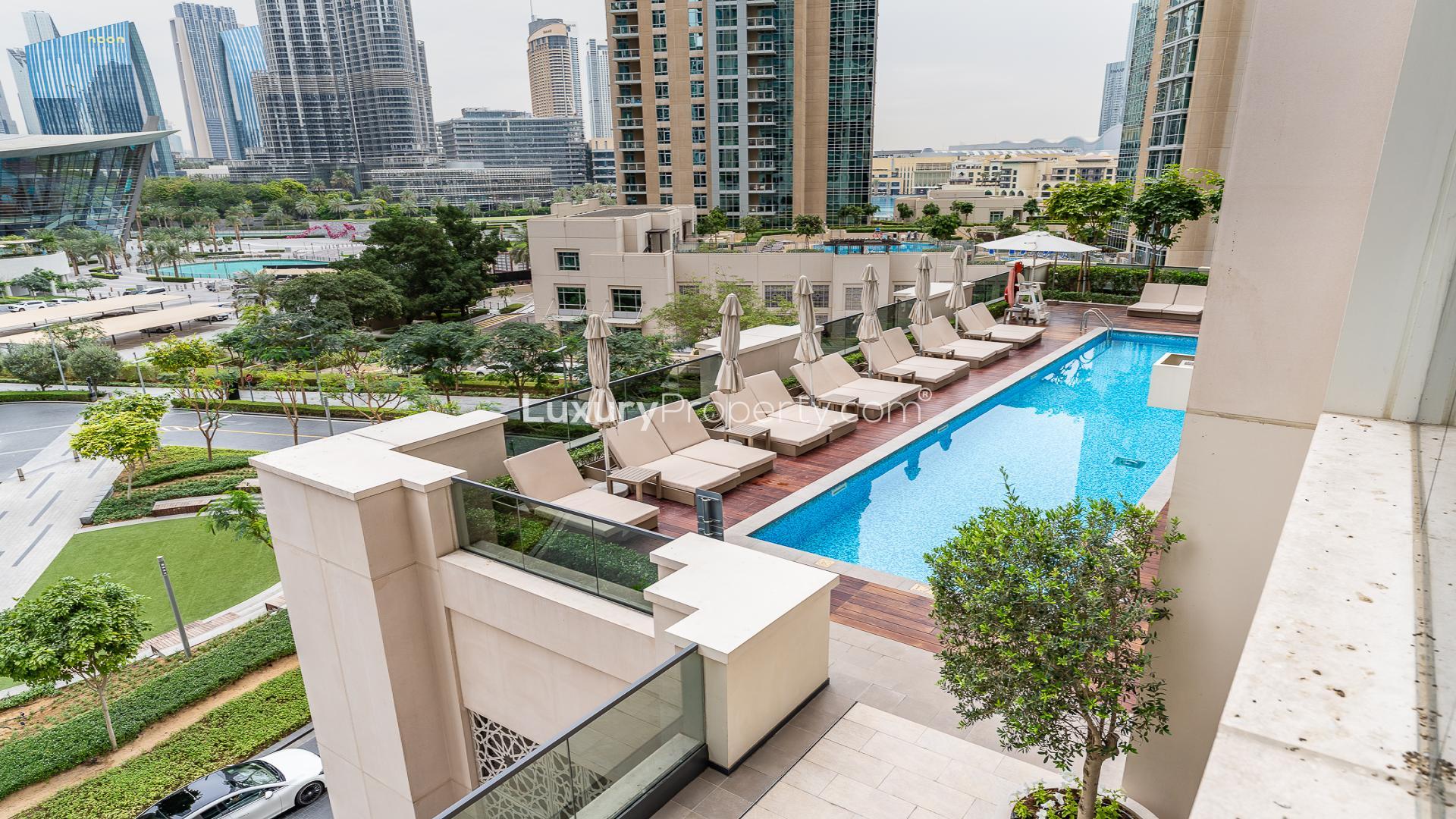"Modern furnished living room in 2-bedroom Downtown Dubai apartment for sale, Act Towers.","Downtown Dubai Act Towers apartment pool view, luxury residential property for sale.",Modern furnished apartment with Burj Khalifa view in Act Towers, Downtown Dubai