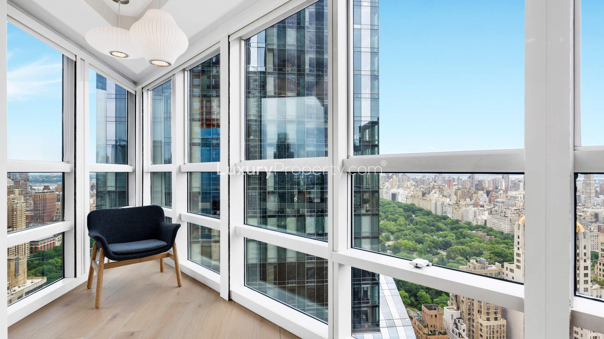 Sleek modern kitchen in modish Manhattan apartment, featuring white cabinetry and stainless steel appliances