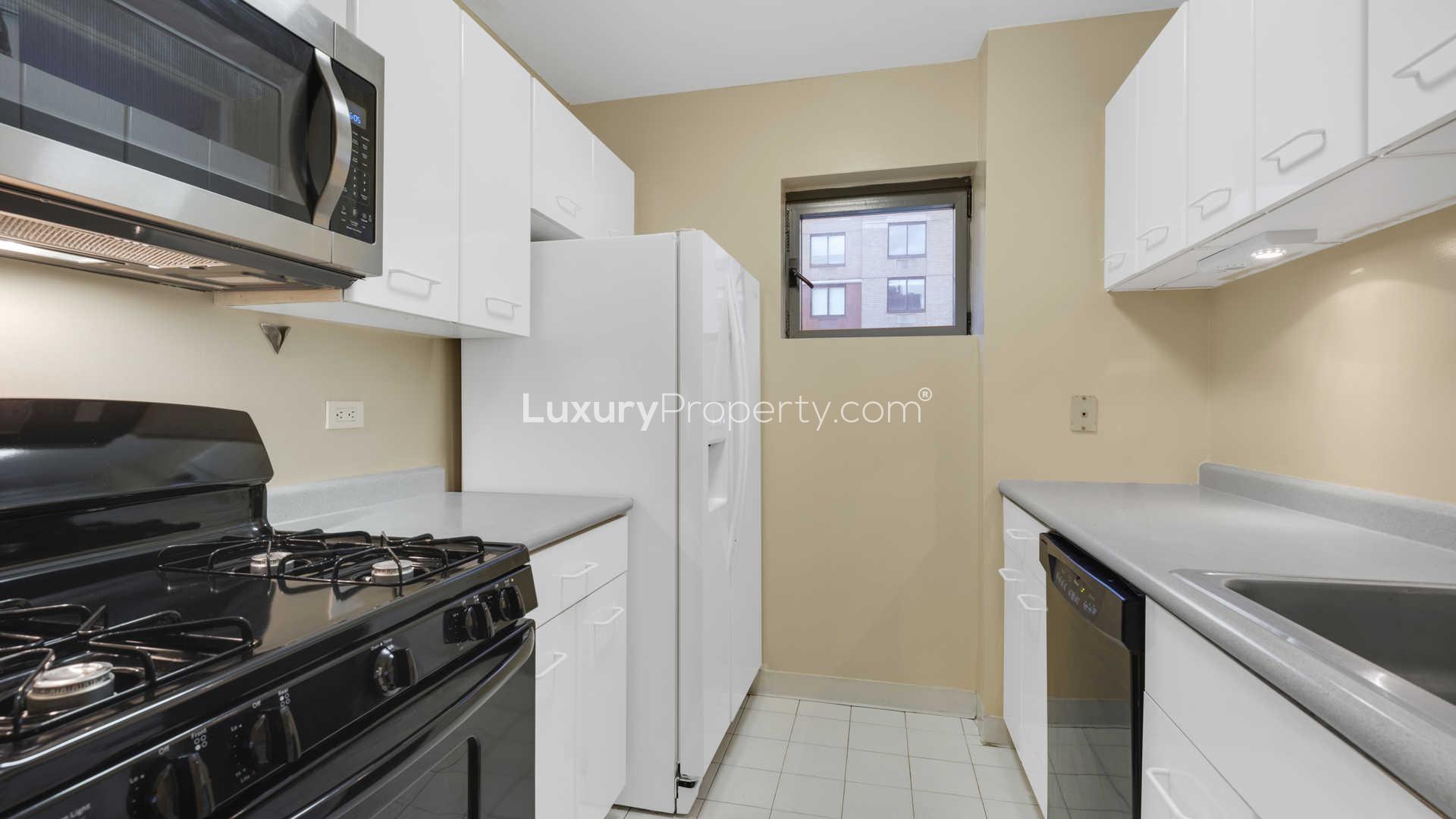 Bright bedroom with city views, desk, and single bed in Manhattan apartment for sale