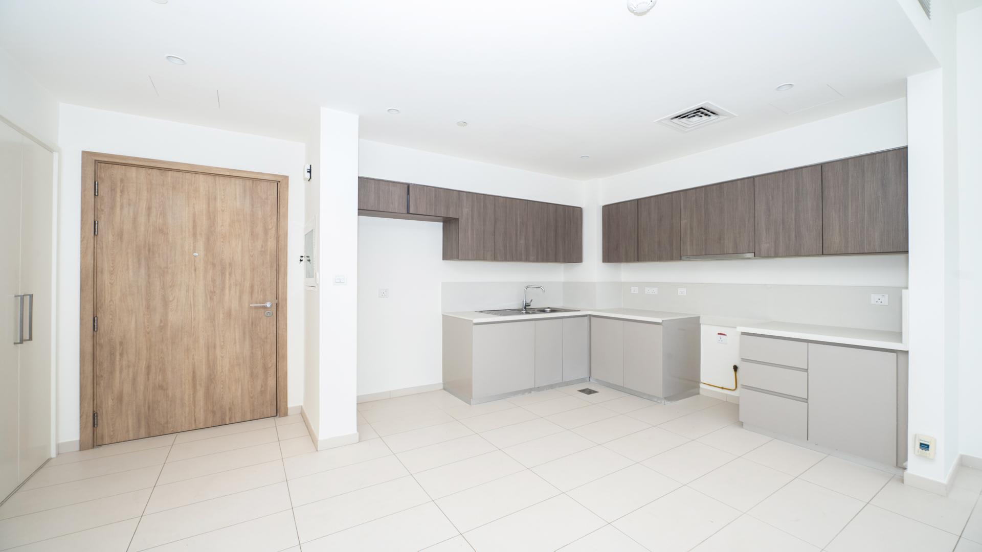 Bright empty room with large window view of Dubai Hills skyline, Park Ridge apartment