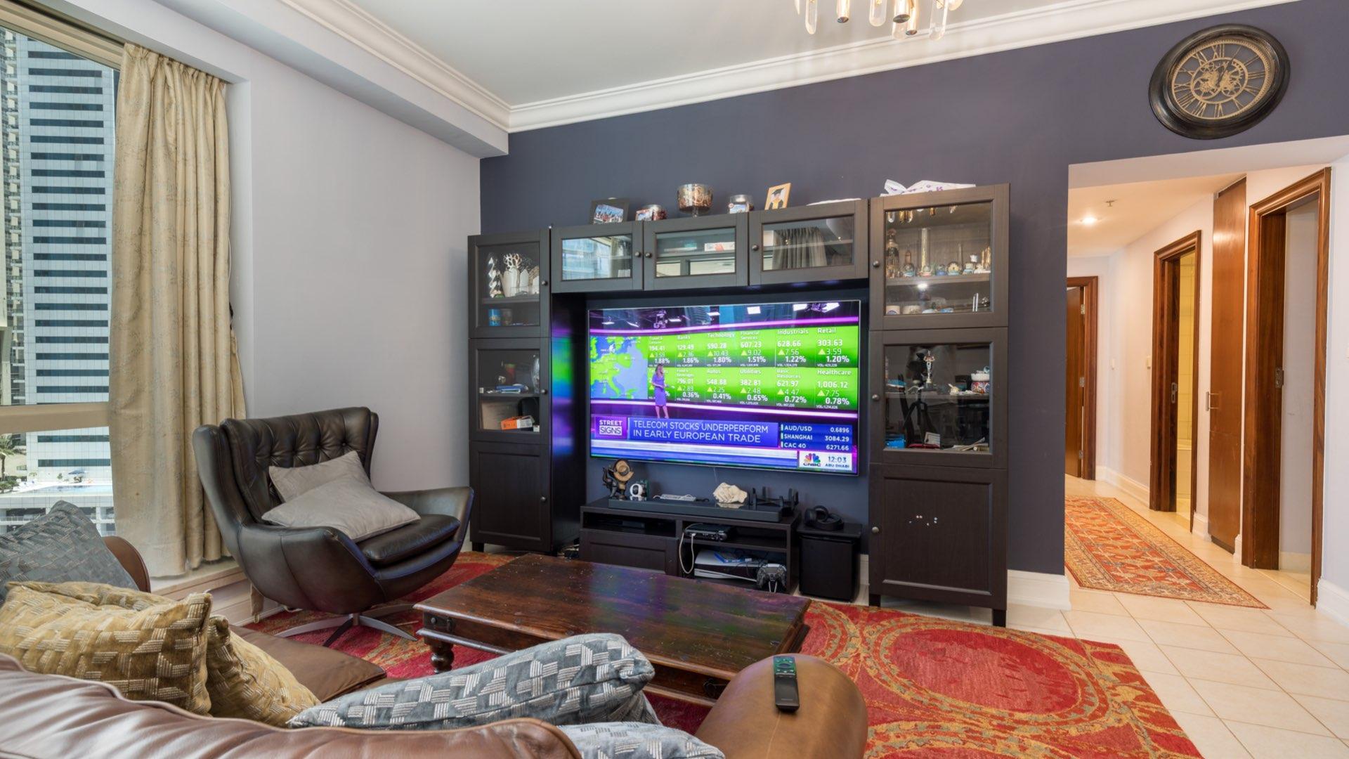 Spacious living room in Dubai Marina apartment with elegant furnishings and large windows