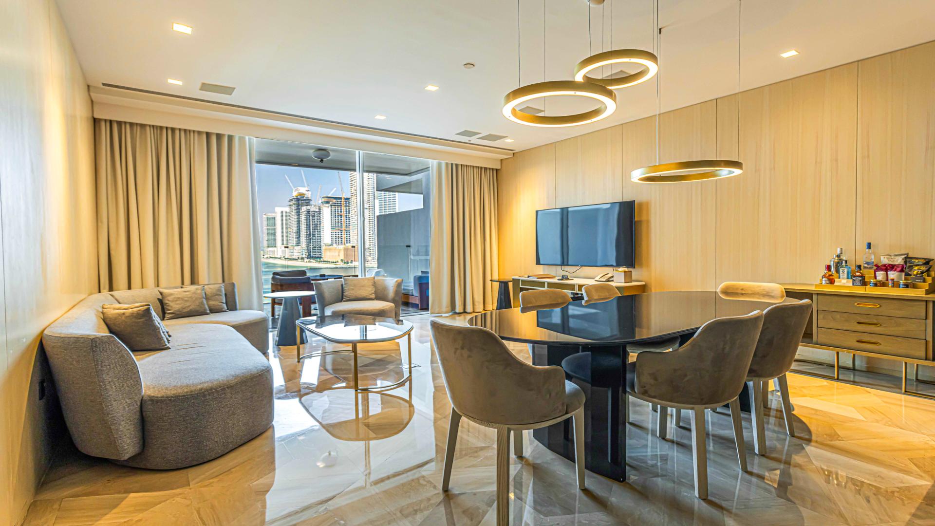 "Luxurious living room in two-bedroom apartment, FIVE Palm Jumeirah, with modern decor and dining area.",Modern living area in FIVE Palm Jumeirah apartment with skyline view, featuring elegant decor