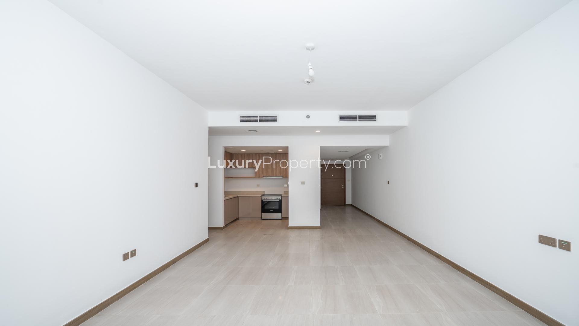 Empty living room with large windows in Business Bay Urban Oasis apartment for sale