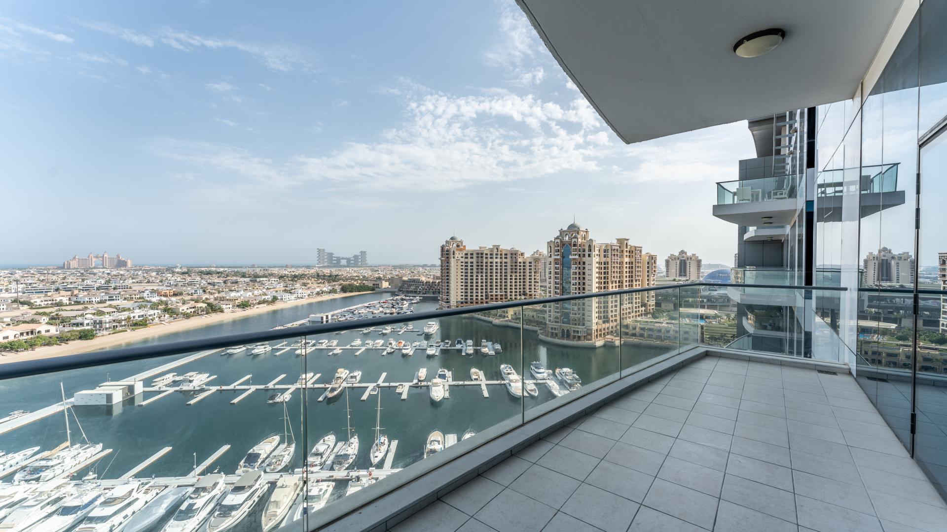 Spacious living room with large windows offering stunning Palm Jumeirah and sea views