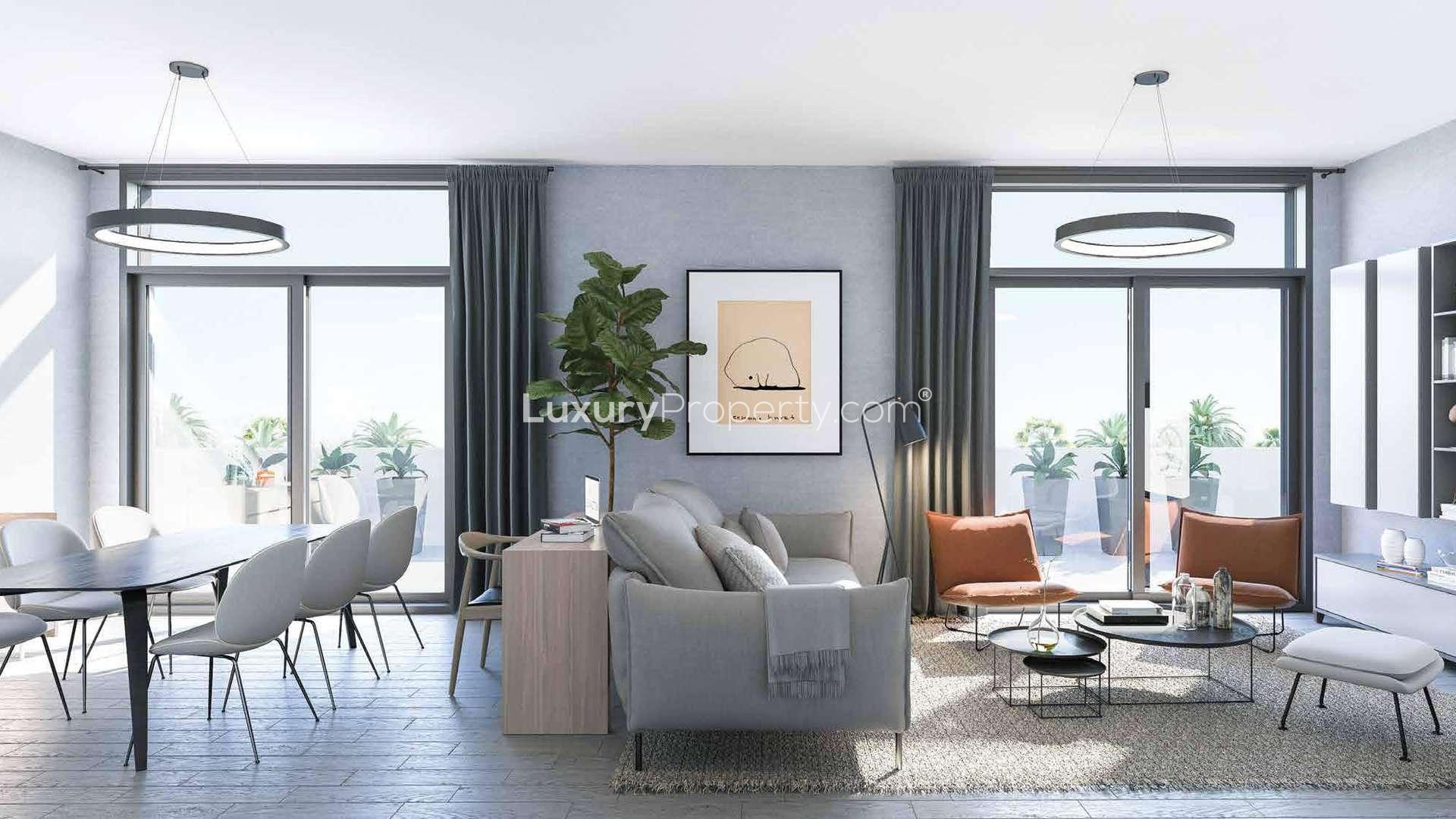 Modern living room in Belgravia III apartment, Jumeirah Village Circle, with large windows and seating