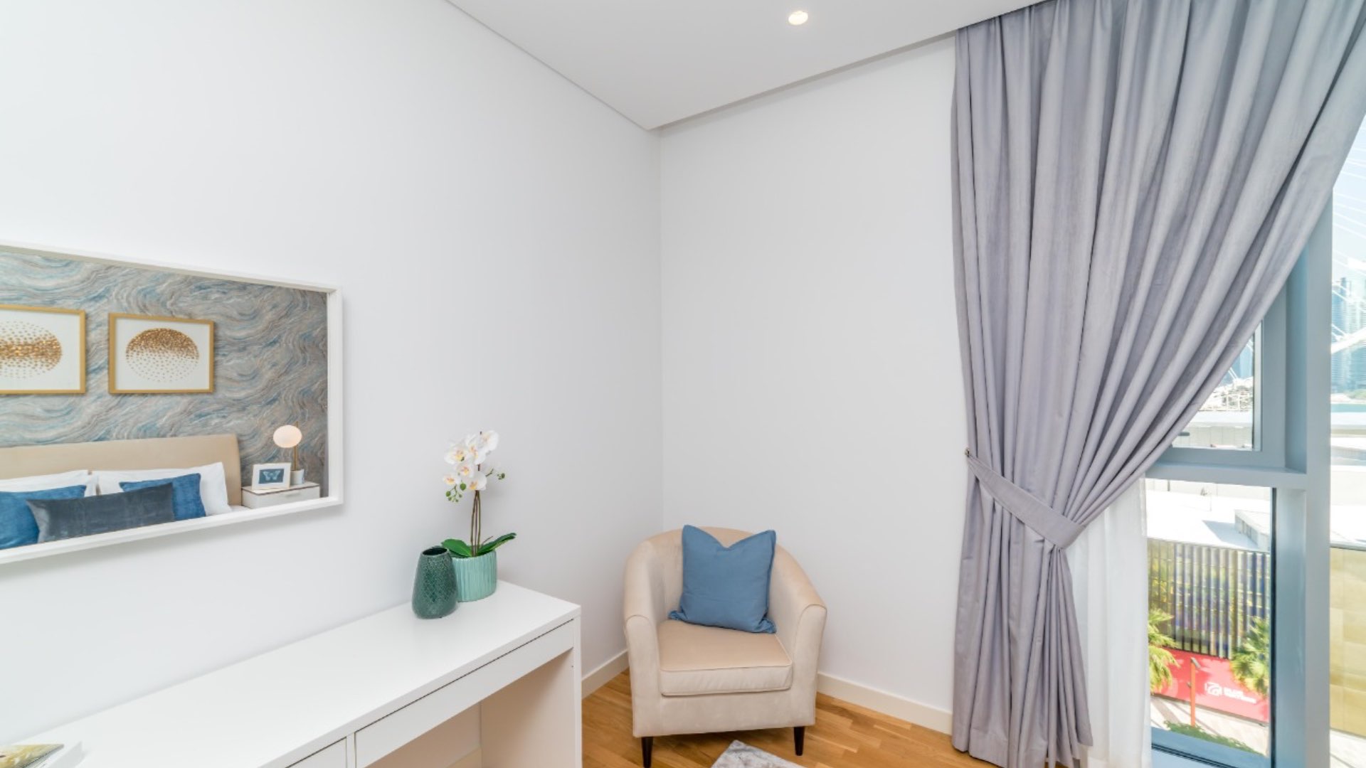 Cozy corner in Bluewaters Residence apartment with armchair, window, and decor accents