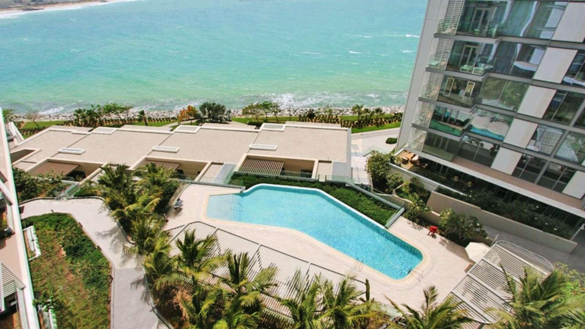 Luxurious poolside view at Bluewaters Residences apartment with sea and Ain Dubai backdrop