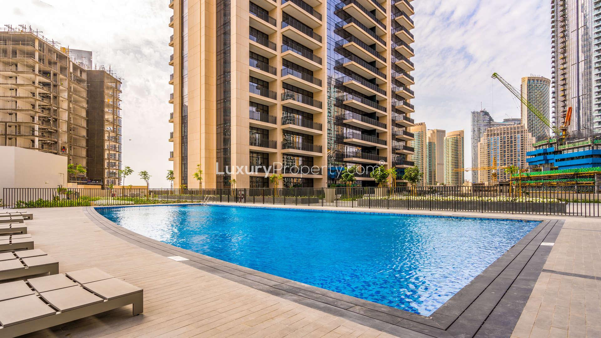 "Modern lobby of Boulevard Crescent apartment in Downtown Dubai with elegant decor and seating.",Outdoor swimming pool at Boulevard Crescent apartment complex, Downtown Dubai, with city views