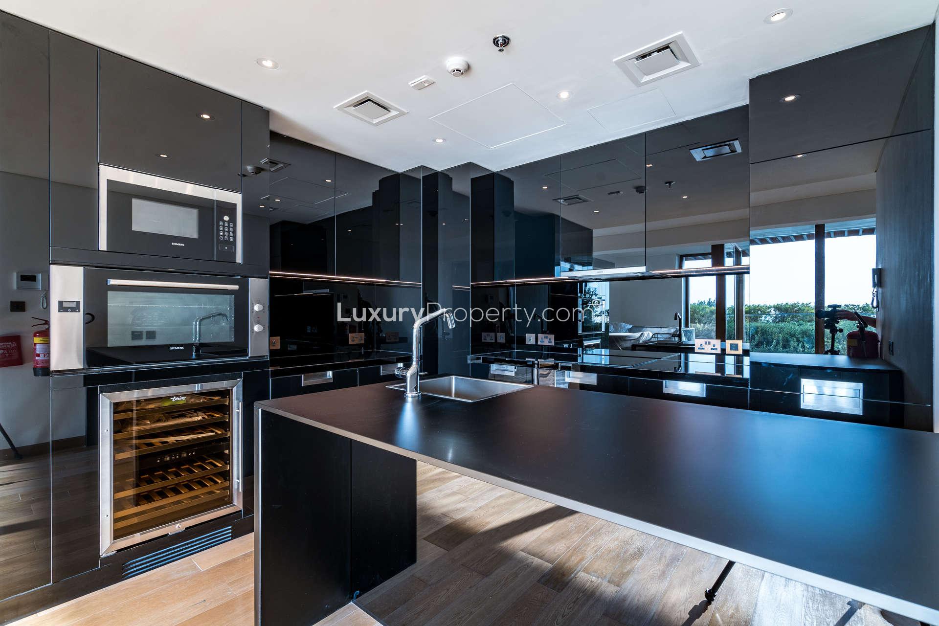 Waterfront view of luxury apartments and yachts at Bulgari Resort, Jumeirah Bay Island