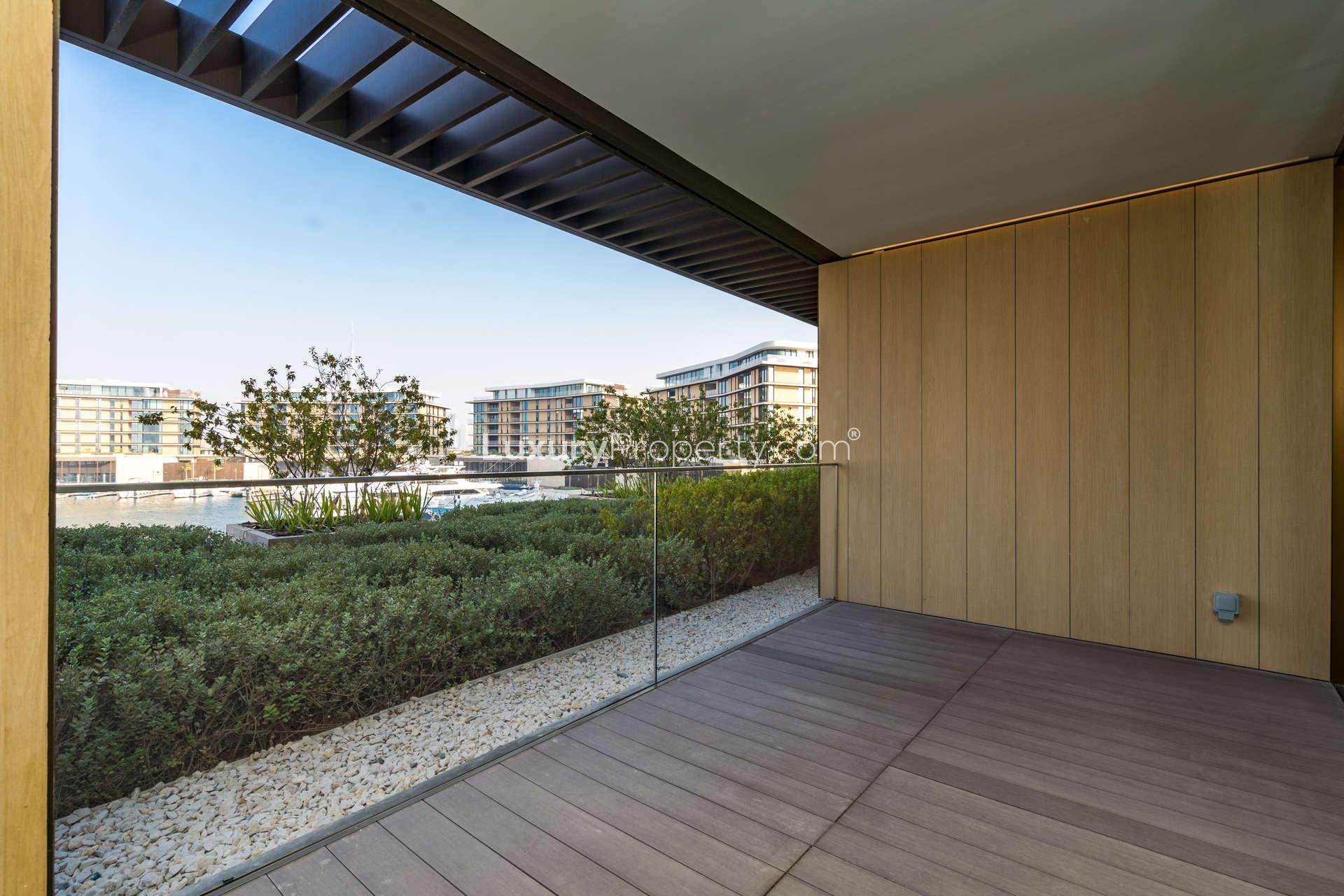 Spacious living area with glass doors in beachfront apartment, Jumeirah Bay Island, for sale