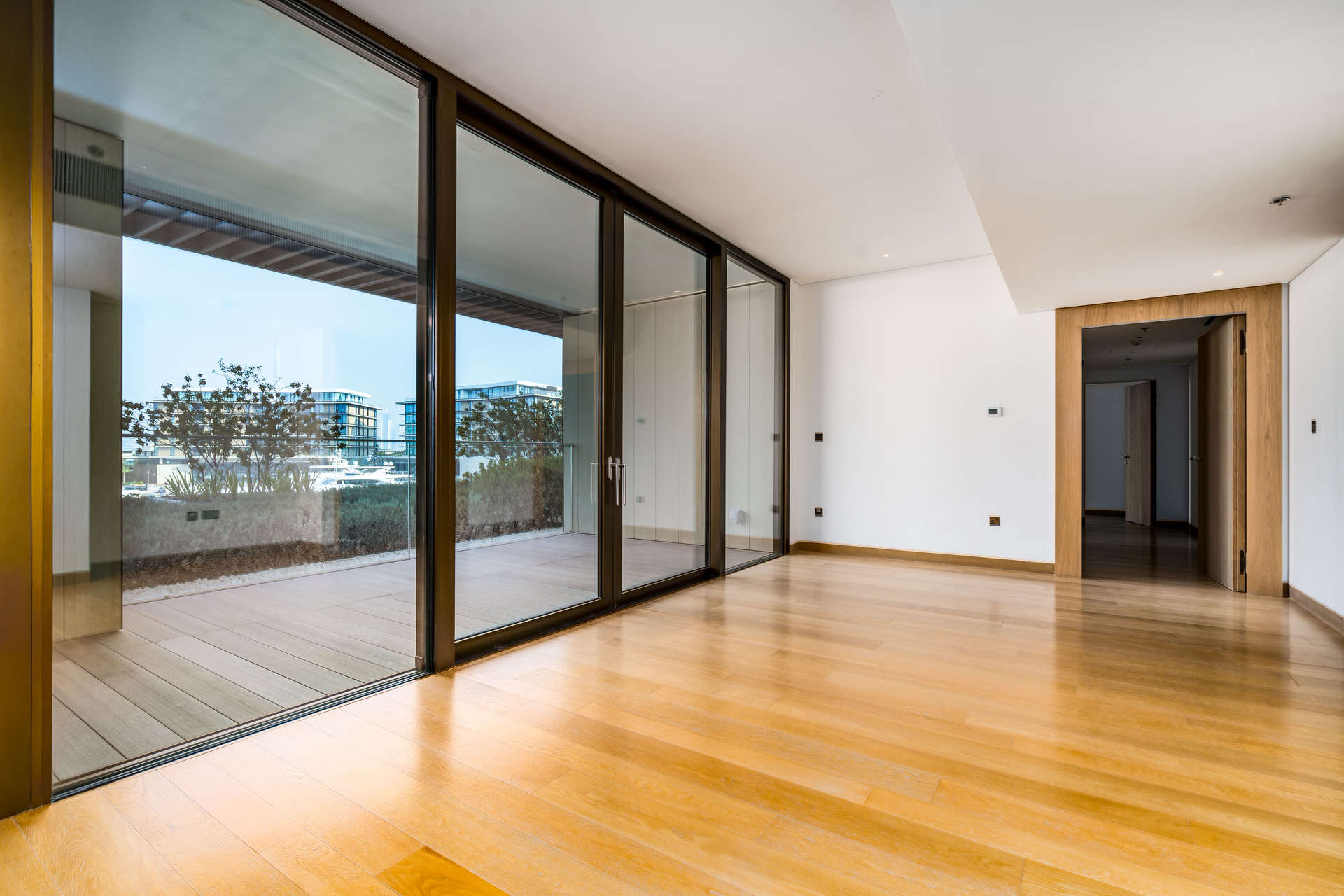 "Stunning view of Bulgari Residences, Jumeirah Bay Island, with marina and lush greenery.","Spacious living area with large windows in beachfront apartment, Jumeirah Bay Island.",Modern interior of two-bedroom apartment at Bulgari Residences, Jumeirah Bay Island