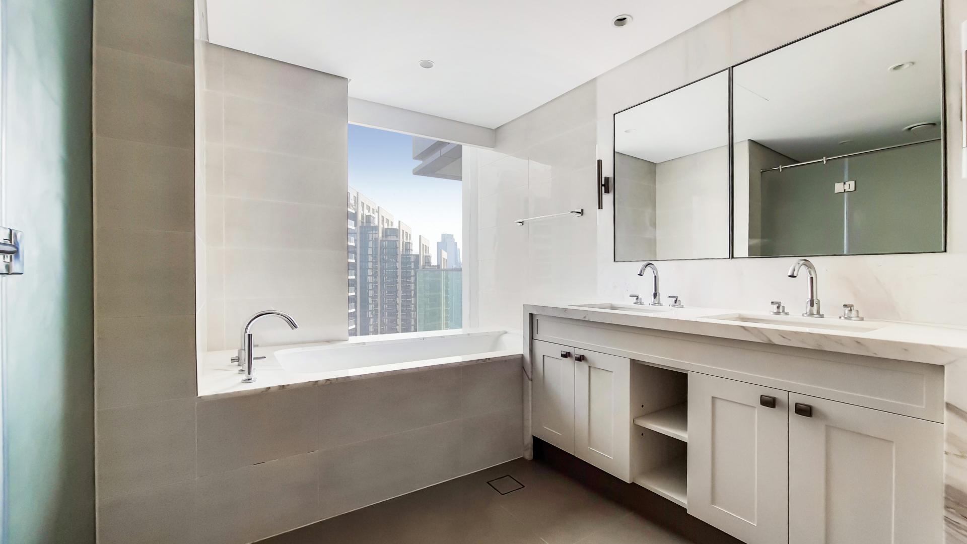 "Modern bathroom in Downtown Dubai apartment with city view, dual sinks, and bathtub.",Brand new apartment in Burj Khalifa Area with spacious living room and large windows