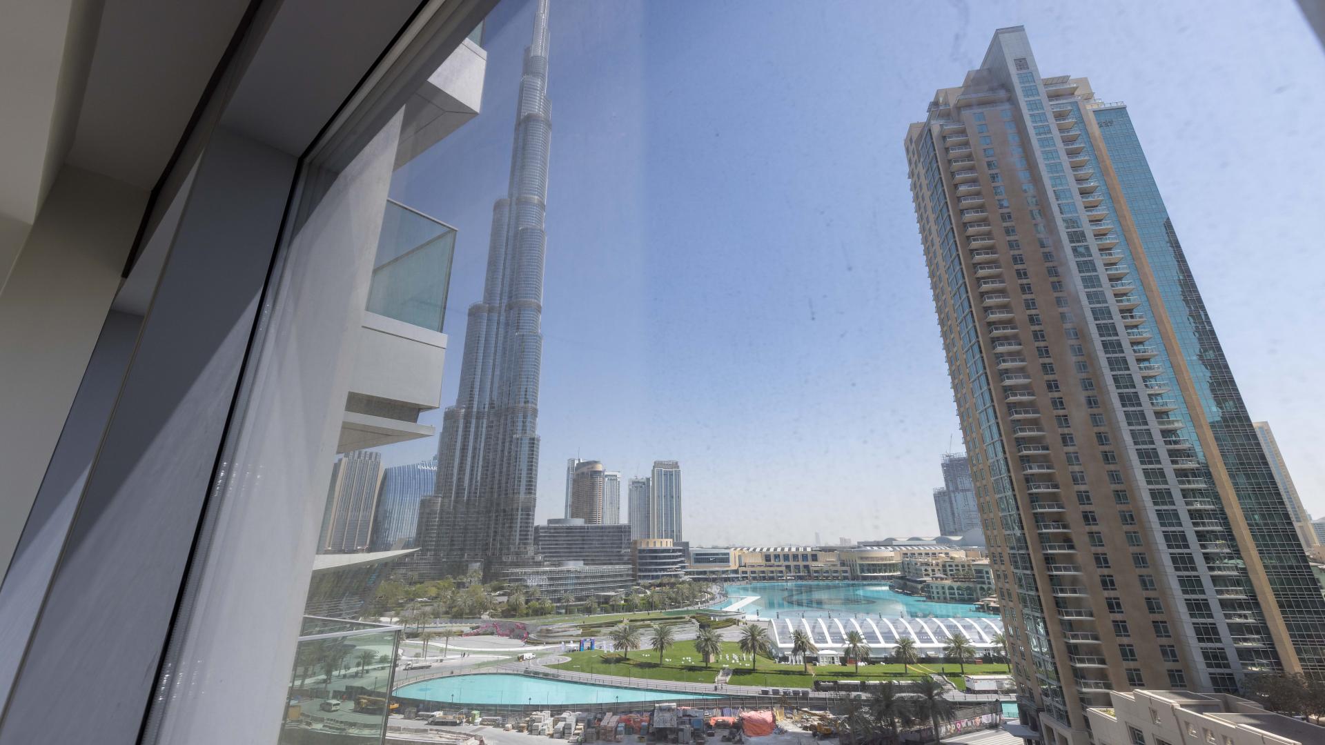 "Bright, spacious living area in brand new Downtown Dubai apartment, Burj Khalifa Area.","View from spacious Downtown Dubai apartment overlooking Burj Khalifa and surrounding skyline.",Modern kitchen with wooden cabinetry in Downtown Dubai apartment for sale, Burj Khalifa area