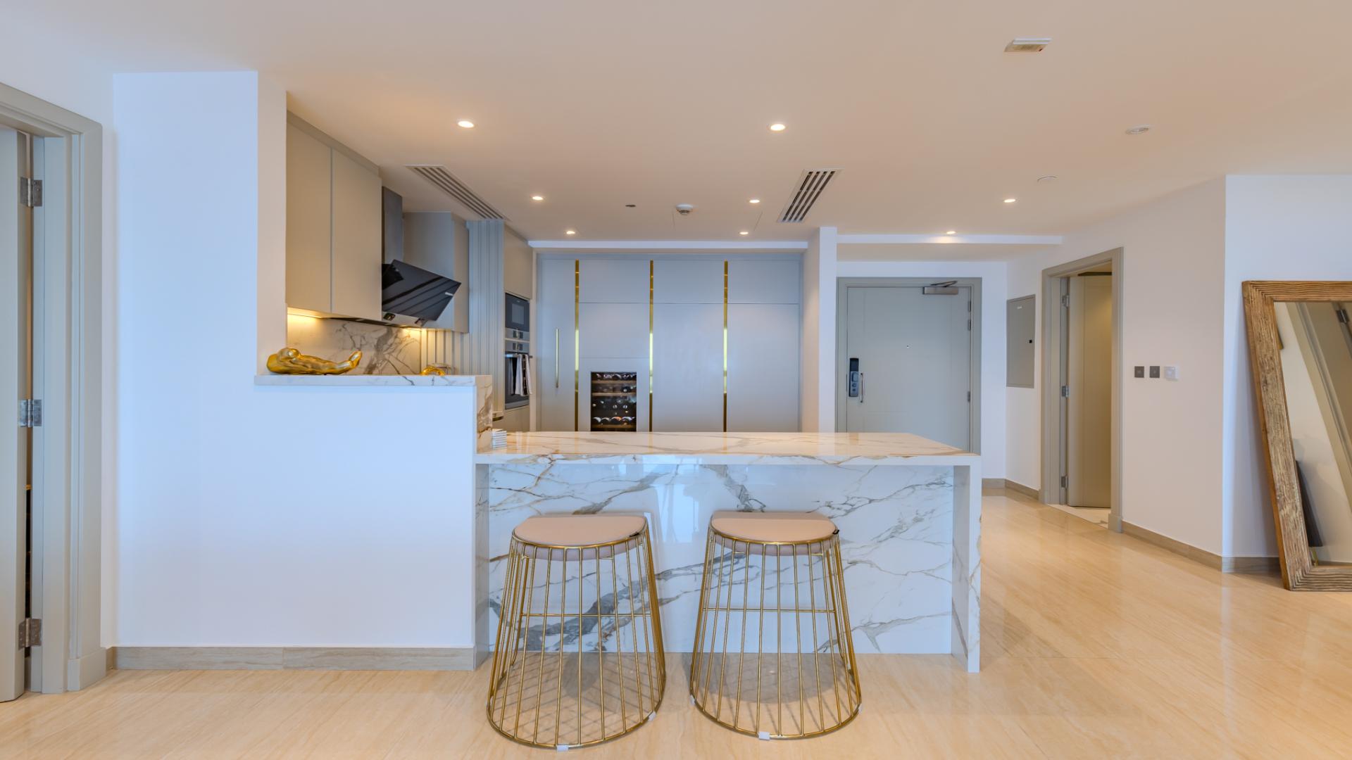 Modern kitchen with marble island in renovated Palm Jumeirah apartment, Marina Residences