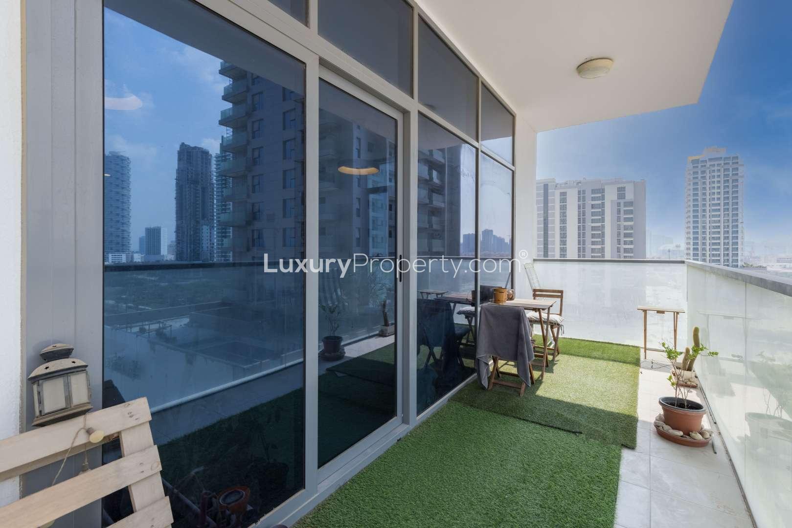 Modern open-plan living area in JVC apartment with large windows and stylish decor