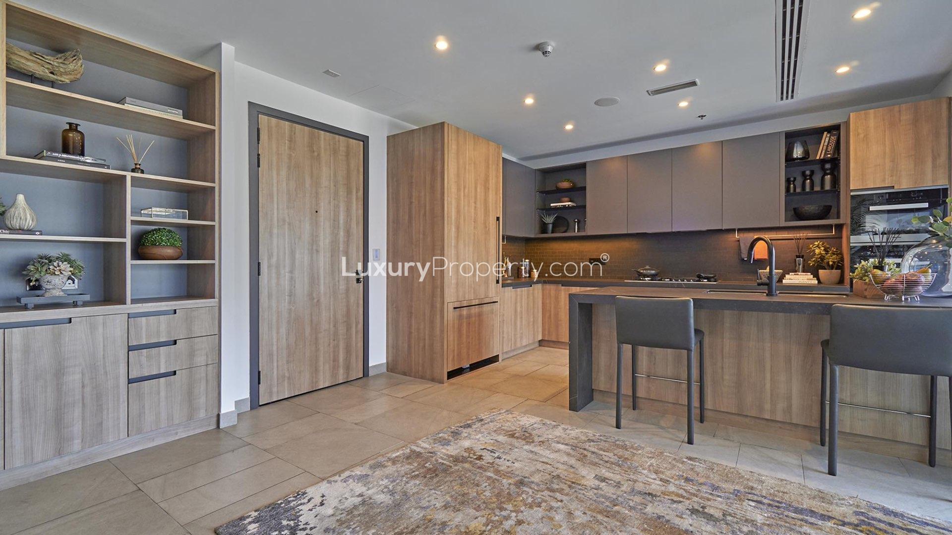 "Modern kitchen in high-floor DT1 apartment, Downtown Dubai, with stylish wood cabinetry and island.",Modern kitchen in high-floor DT1 apartment, Downtown Dubai. Spacious design, elegant wood finishes