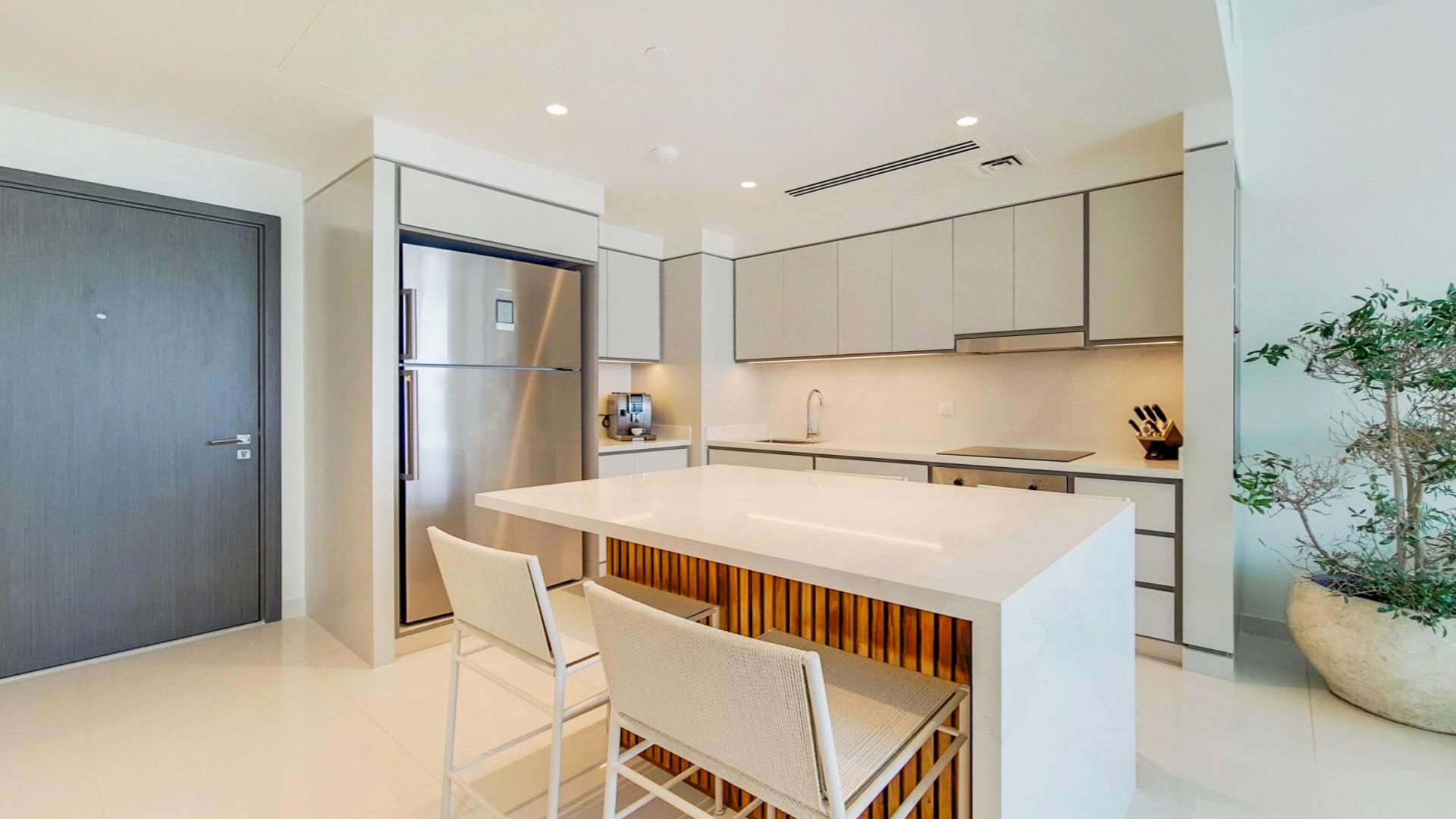 Modern kitchen in Emaar Beachfront penthouse apartment, Dubai Harbour, with sleek cabinetry and island