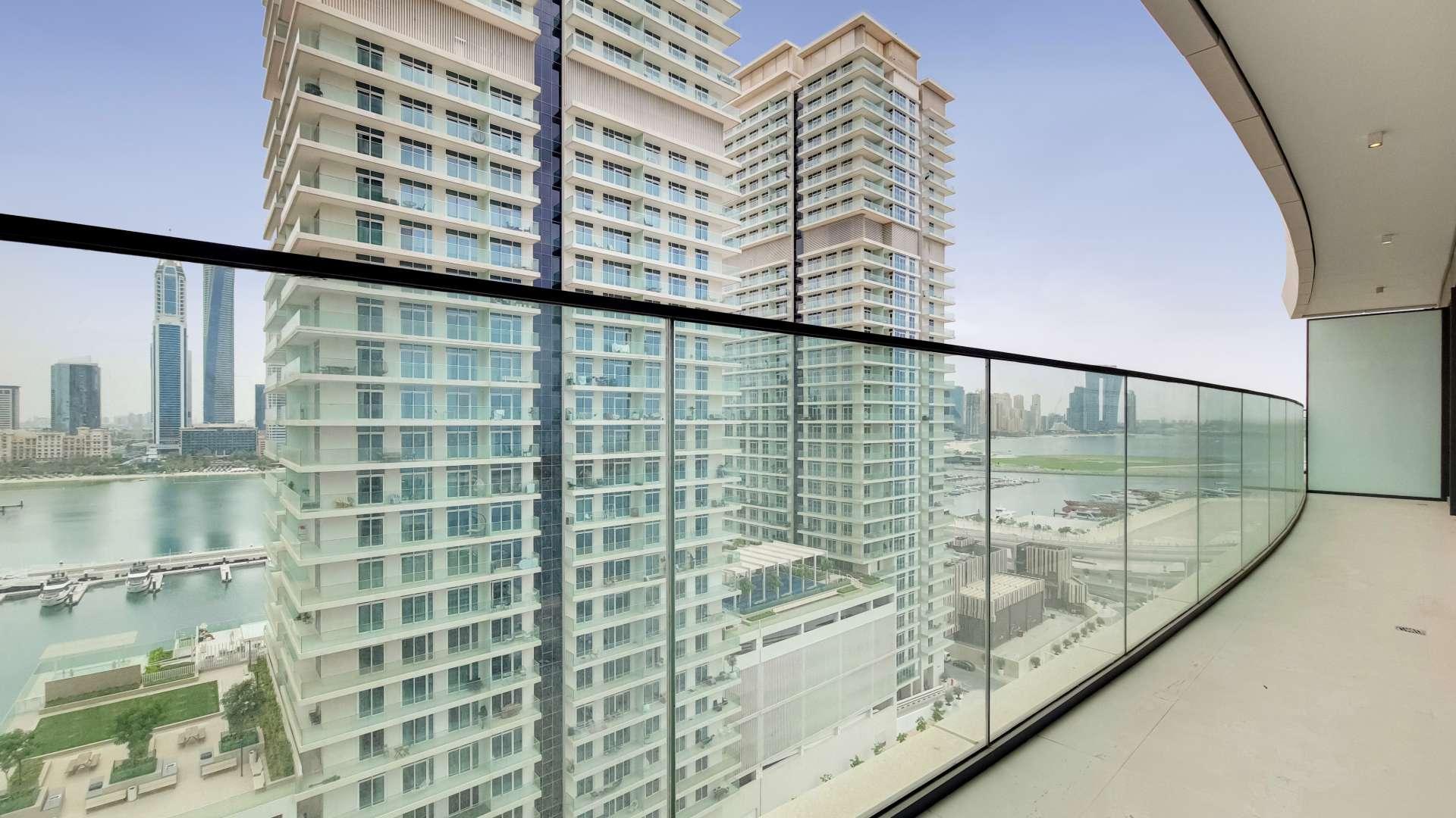 "Spacious living area in Emaar Beachfront apartment with floor-to-ceiling windows, Dubai Harbour views.",Panoramic balcony view from beachfront apartment in Emaar Beachfront, Dubai Harbour
