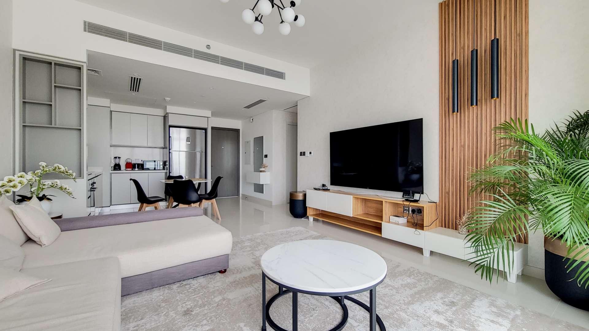 Modern living room in Emaar Beachfront apartment, Dubai Harbour, with elegant decor and balcony view