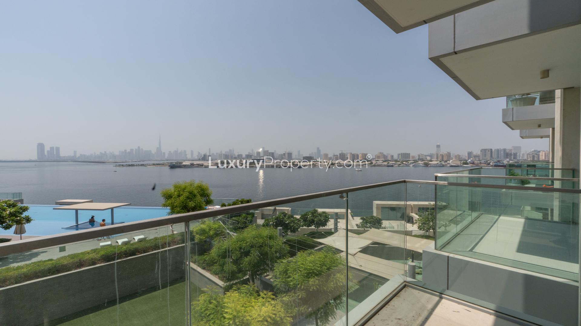 Modern living room in The Grand apartment, Dubai Creek Harbour, featuring balcony with waterfront view
