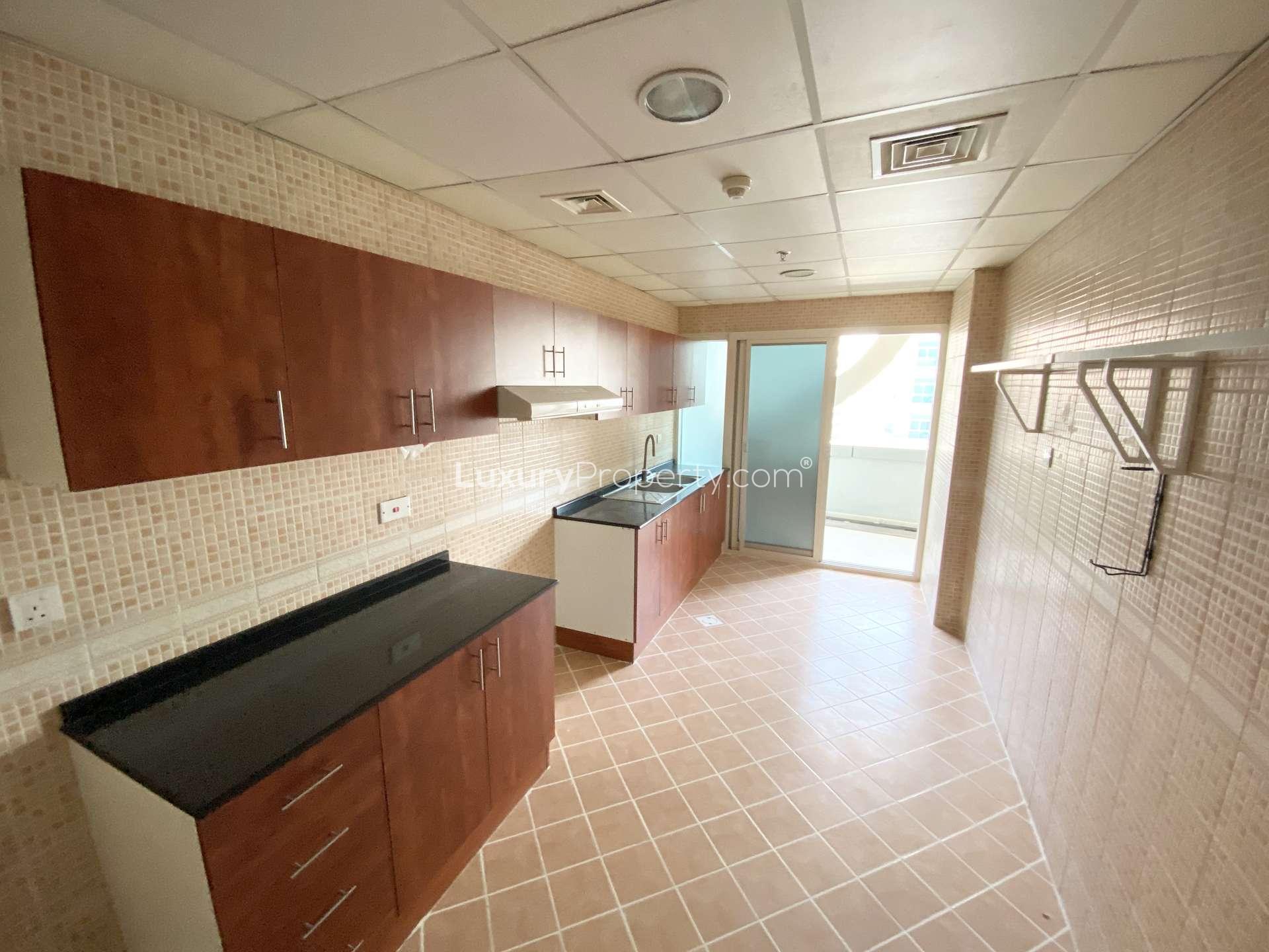 Bright living room in Olympic Tower 2 apartment, Dubai Sports City, with large windows and sofa