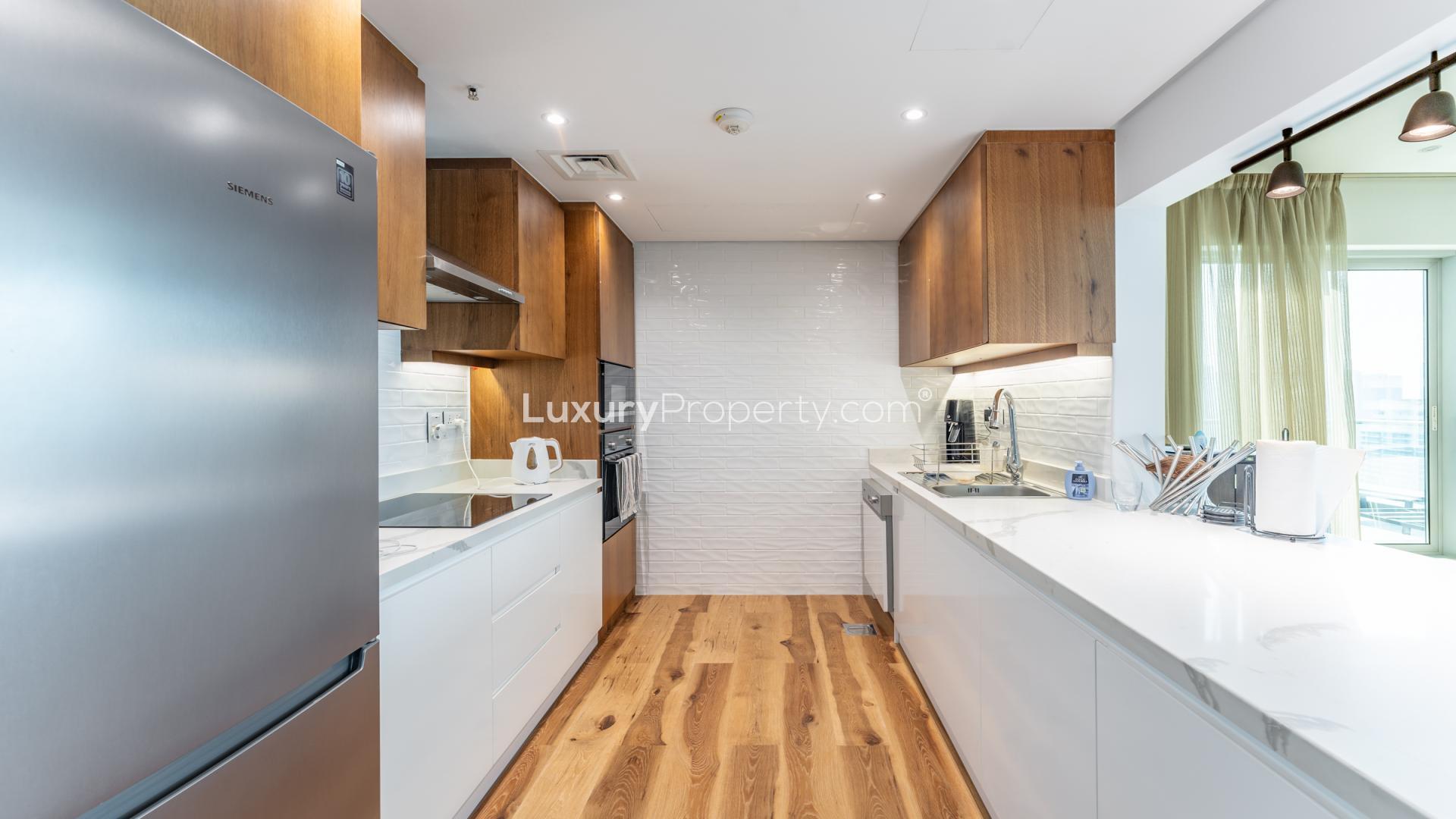 "Stunning Dubai Marina skyline view from apartment balcony in Marina Promenade, for sale.",Modern kitchen in 2-bedroom apartment, Marina Promenade, Dubai Marina, with sleek appliances and finishes