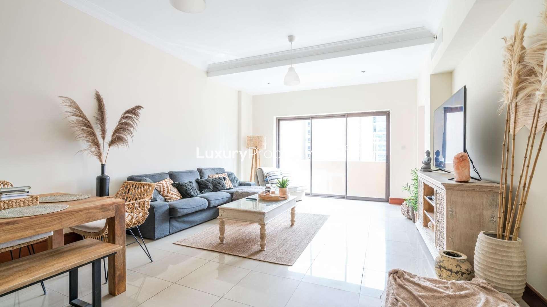 Bright balcony with gym equipment overlooking lush park walkways in Palm Jumeirah apartment